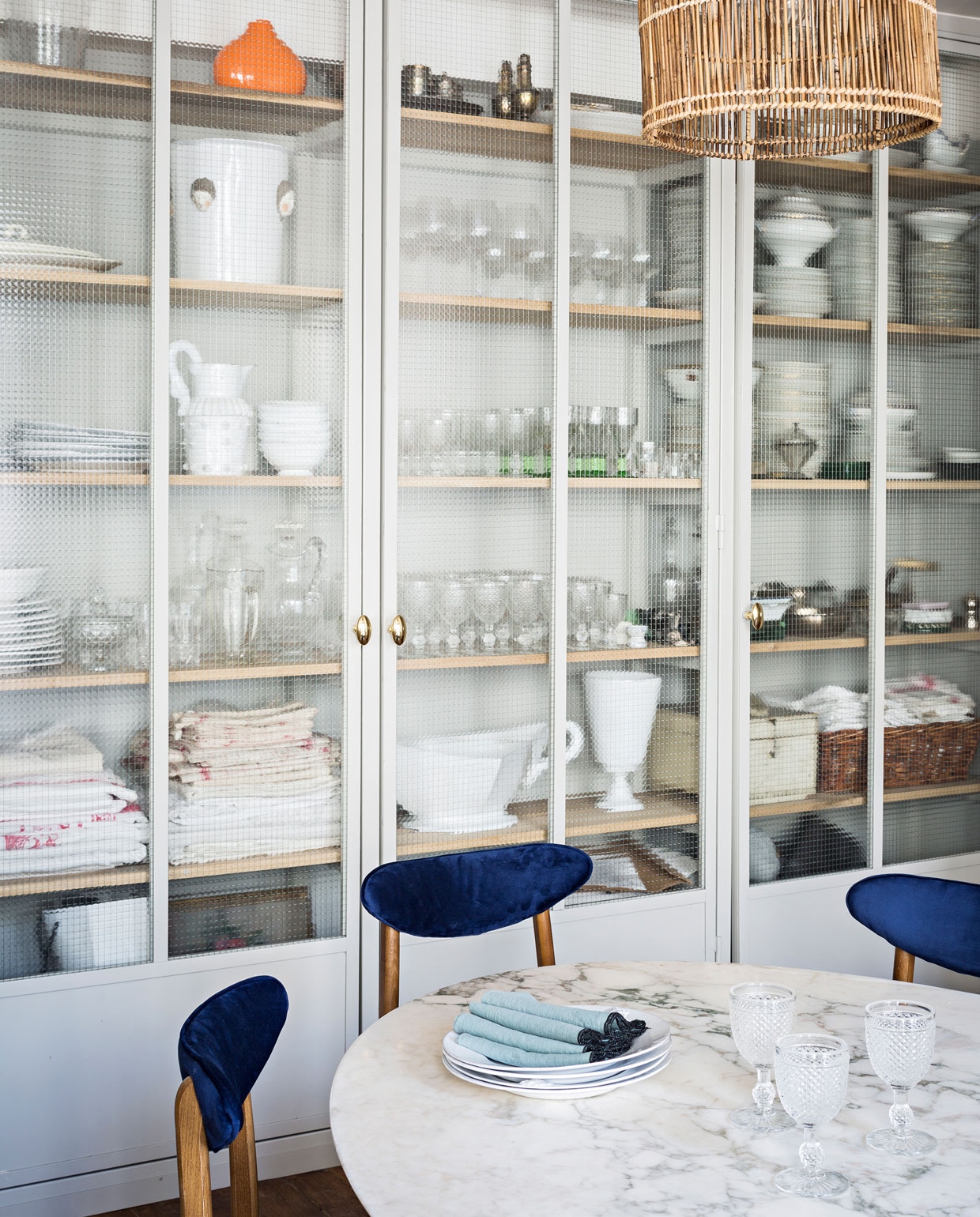 De vintage Knoll tafel is gekocht op een veiling, stoelen zijn van The Cool Republic, net als de rotan lamp. Het porseleinen plafondlampje is van Zangra.