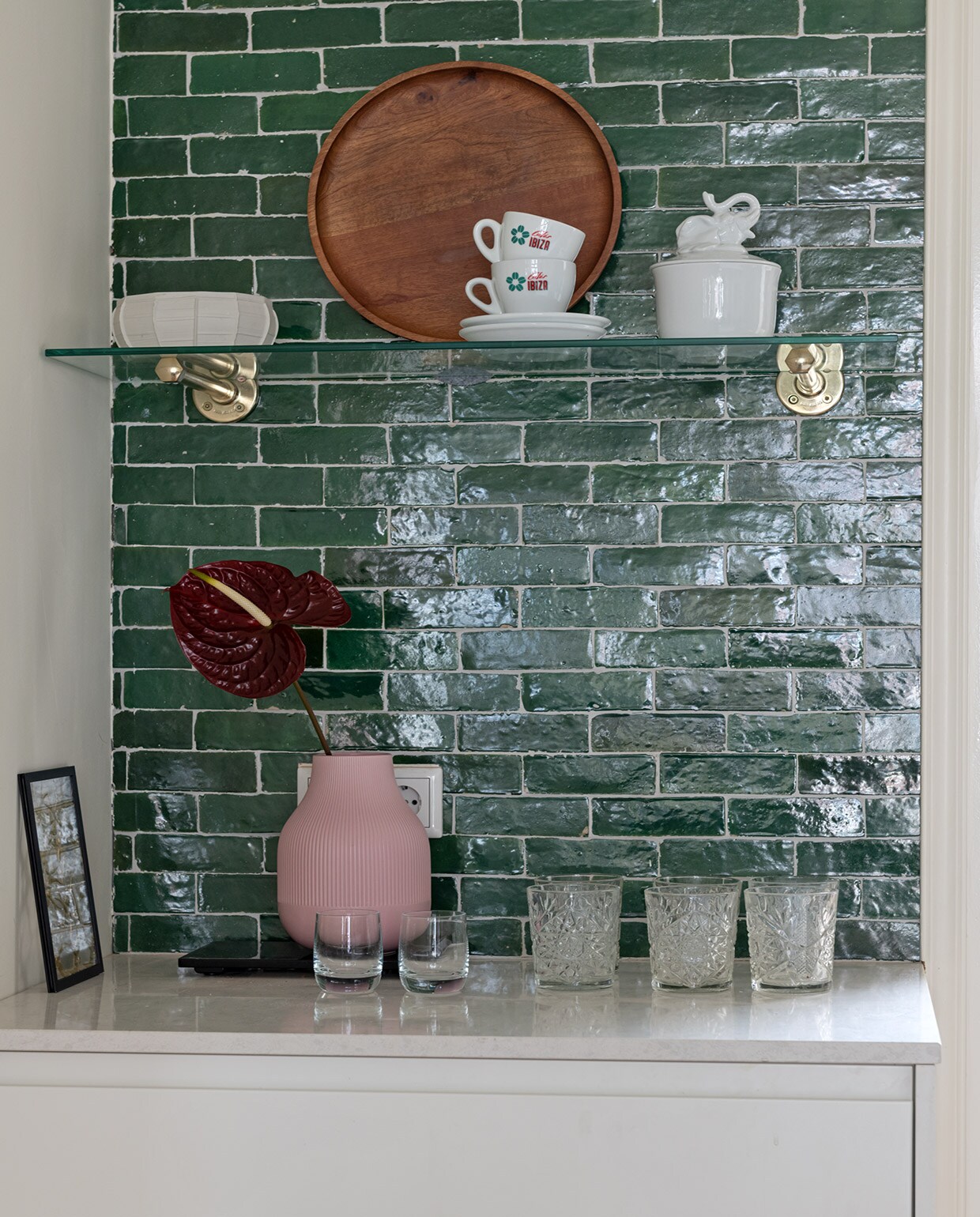 Tegels Bejmat in kleur Vert Foncee Designtegels. Porseleinen schaal Serax. Houten dienblad H&amp;M Home. Kop en schotel kringloopwinkel. Porseleinen schaal met olifant &amp;Klevering. Zwart lijstje Moebe. Roze vaas Ikea. Set whiskyglazen Glenfarclas Schotland. Glazen Libbey. vtwonen special tiny houses | Styling Sharon Roest | Fotografie Caroline Martinot