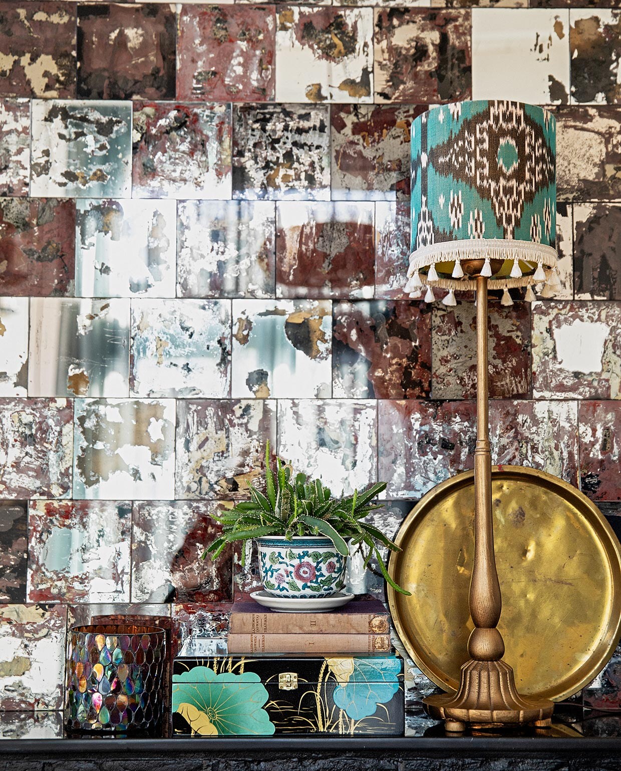 Spiegeltegels Praxis zelf bewerkt voor een verweerd effect, lampvoet kringloop zelf goud gespoten, kap van ikat-stof via Capsicum Amsterdam, waxinelichthouder via Bij Lokaal, doosje cadeau, plantenpot en gouden tray Hippe Kringloop. vtwonen 04-2021 | styling Ilona Jongepier | fotografie Dana van Leeuwen