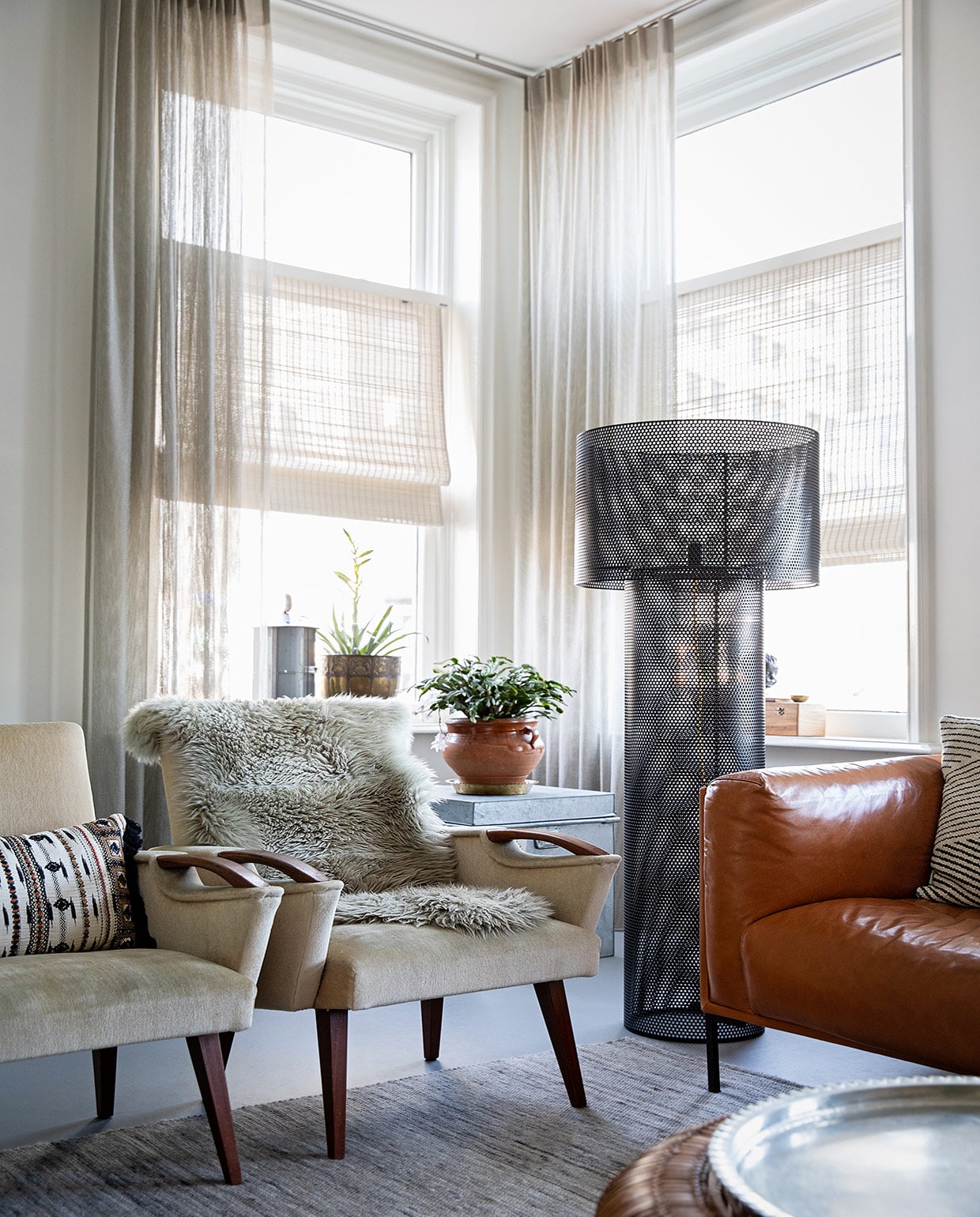 Muurverf Ral 9010 Flexa, gordijnen Sato van Jab Anstoetz, bamboe rolgordijn Sunway, fauteuils erfstukken, kussen op fauteuil Imbarro, dierenvel op fauteuil Karwei, bank Het Anker, zwarte staande lamp via Tica, koperen bloempot van grootouders, metalen blik van Franse antiekmarkt, houten kist cadeau, pot op kist kringloop, metalen kist Kleur op Kleur Interieur, vloerkleed via Woontheater , de Eclips. Hanglamp Ferm Living. Tafels Karwei. vtwonen 04-2021 | styling Ilona Jongepier | fotografie Dana van Leeuwen