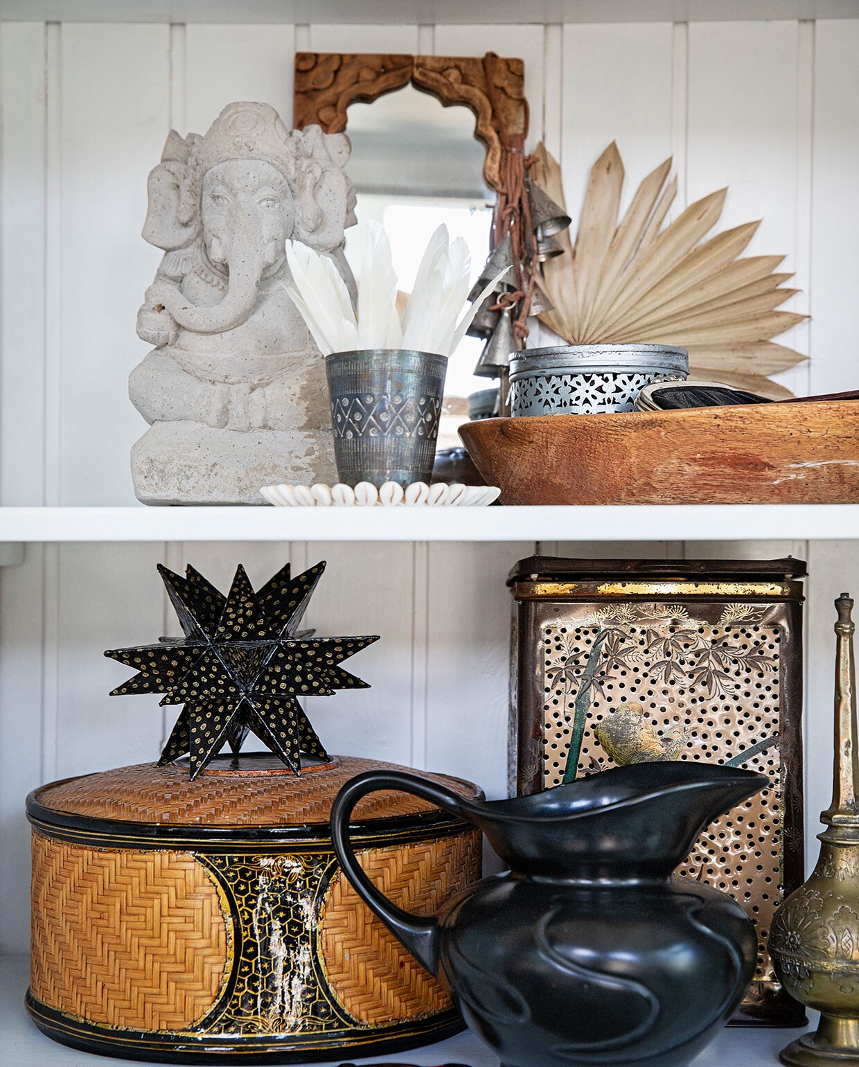 Spiegel en belletjes uit India, Ganesha beeld en houten schaal cadeau gekregen, blad en rotan mand Bij Lokaal, beker vintage uit Denemarken, veren gevonden, onderzetter schelp Laif &amp; Nuver, zeepblik Sissy-Boy, ster zelfgemaakt, brievenopener uit Indonesië, kan en blik kringloop, rozenwatersprinkler uit Tunesië. vtwonen 04-2021 | styling Ilona Jongepier | fotografie Dana van Leeuwen