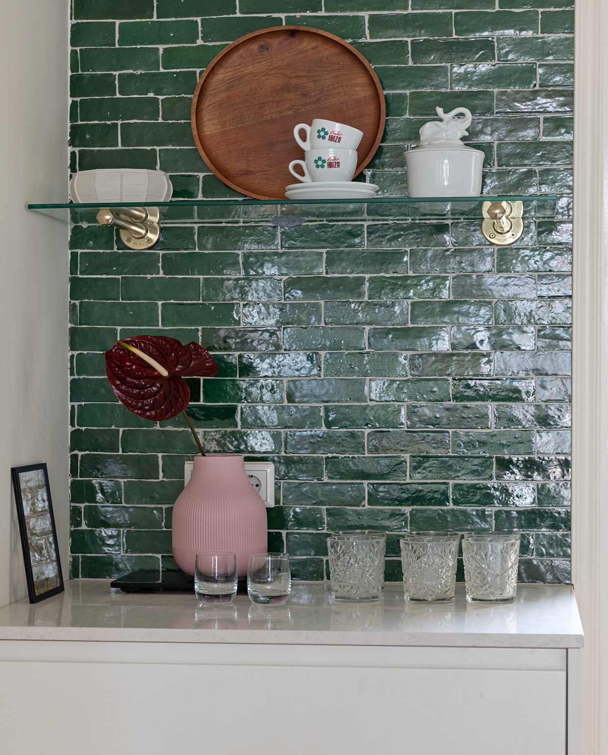 Tegels Bejmat in kleur Vert Foncee Designtegels. Porseleinen schaal Serax. Houten dienblad H&amp;M Home. Kop en schotel kringloopwinkel. Porseleinen schaal met olifant &amp;Klevering. Zwart lijstje Moebe. Roze vaas Ikea. Set whiskyglazen Glenfarclas Schotland. Glazen Libbey. vtwonen special tiny houses | Styling Sharon Roest | Fotografie Caroline Martinot