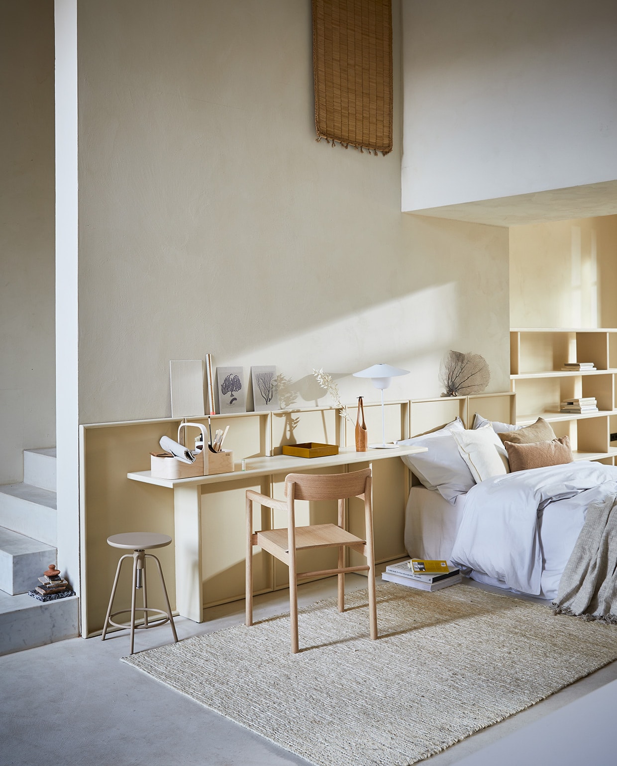 Op maat gemaakt headboard-bureau, prijs op aanvraag (com-anders.nl). Houten stoel Post van Fredericia (designtales.nl). Houten opbergkist met handvat Verso Koppa Tool Box (nordicnew.nl). Kruk Around, ledlamp Ani (blomus.com). Dekbedovertrek van perkal katoen in kleur Pebble (suite207.com). Linnen kussens 55×55 cm, okergeel gelakt dienblad (bungalow.dk). Linnen plaid (hm.com). Japans houten vaasje (japansewinkeltje.nl). Ivoorkleurig vloerkleed van hennep 140×200 cm, kleedje van zeegras (anoukb.com). Overig privébezit. vtwonen 04-2021 | Styling Cleo Scheulderman | Fotografie Jeroen van der Spek\n\nvtwonen 04-2021 | lichte kleuren in de slaapkamer met bureau