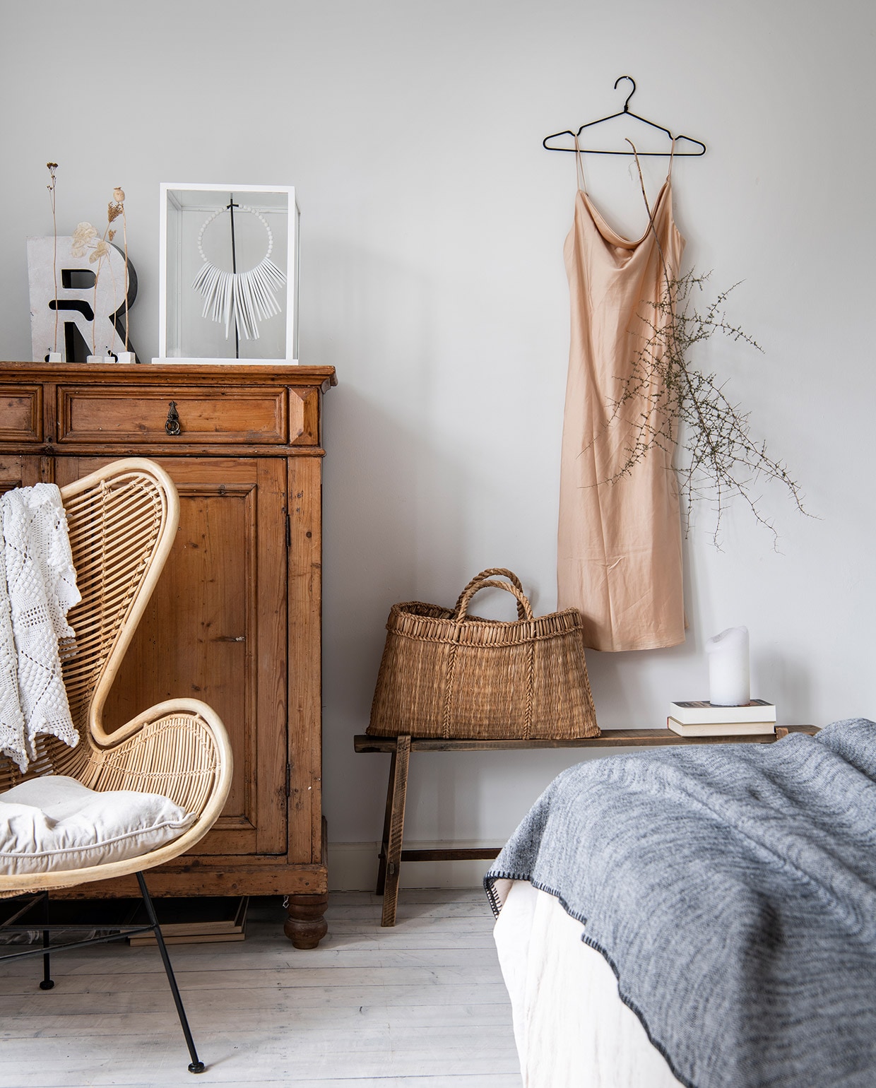 Bed Dreamliner via intense-boxsprings.nl, beddengoed Passion for Linen. Stoel HKliving, kast herkomst onbekend. Letter R en rieten tas kringloop Allerhande Panningen. Glazen box met ketting Kwantum, houten bank Xenos, nachthemd Zara, kaars Hema, droogbloemen in houders Nadesign, tak uit de tuin. vtwonen 04-2021 | productie Insidehomepage | styling Marit Saladini | fotografie Louis Lemaire