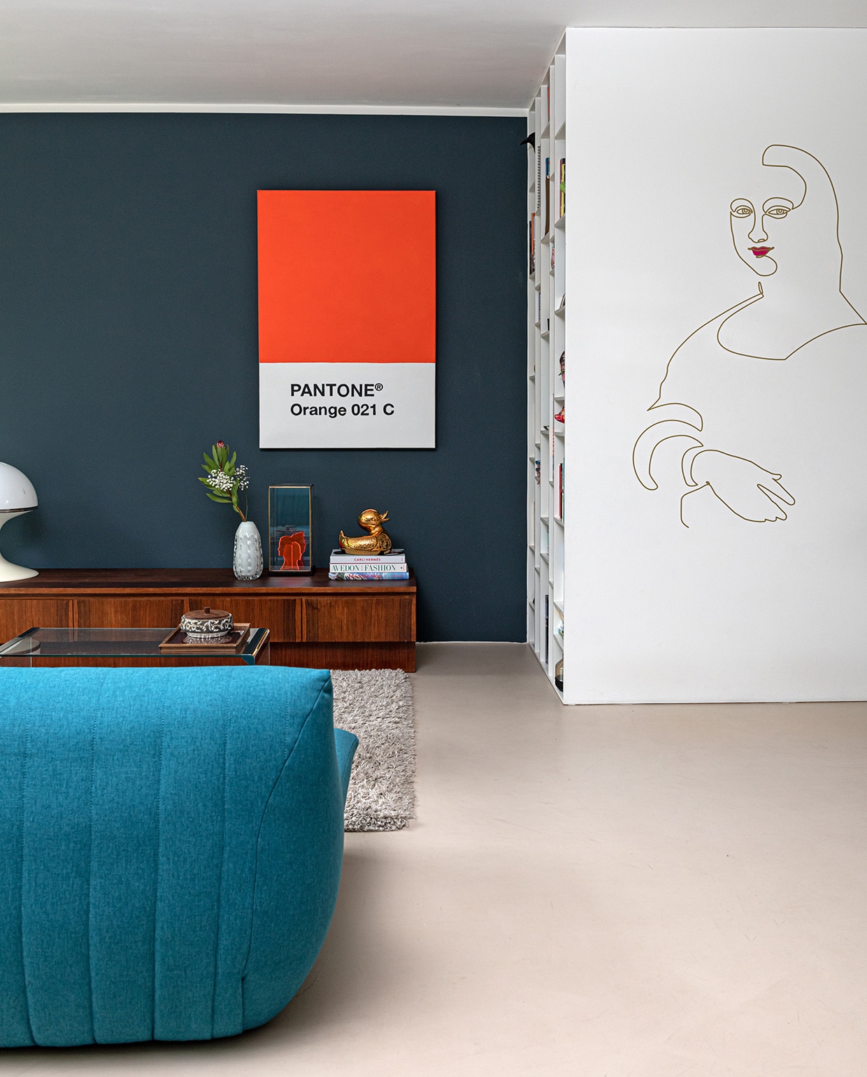 Pantone poster eigen ontwerp Charlotte, muurschildering Mona Lisa van oneline eigen ontwerp Michel. Glazen tafel Marktplaats. Bakje van keramiek vintage. Kleed Shaggy van Trendcarpet, bank Made, dressoir vintagevirus.nl, lamp Concept van Brabantia. Vaas kringloopwinkel. Portretten van acrylaat eigen ontwerp, in vitrine van HKliving. Eendje Jasmin Djerzic. Kast eigen ontwerp, productie interieurbouw Niels Breuer. vtwonen 04-2021 | styling Sharon Roest | fotografie Caroline Martinot