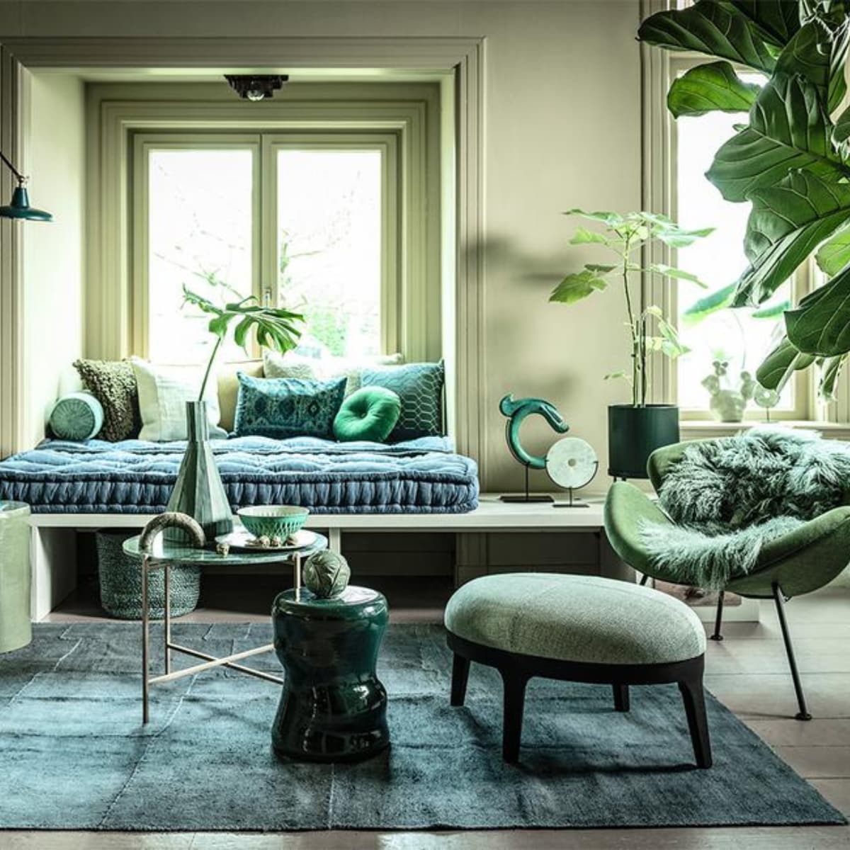 Fauteuil links € 795,- (flinders.nl). Bank op maat gemaakt, prijs op aanvraag (com-anders.nl). Zitting bank twee stuks op maat gemaakt, 210×80 cm € 690,-, geel/groen langwerpig kussen € 154,- (coco-mat.com). Fauteuil Orange Slice van Artifort € 1972,-, cactus van Hay € 75,- (homestede.nl). Marmeren tafel € 95,-, kruk links € 195,-, kruk midden € 103,95, kussen langwerpig met oude opdruk € 69,-, ronde sierbol op kruk prijs op aanvraag, sierobject draak € 129,95, vacht € 99,-, (loods5.nl). Poef € 1150,-, grof kussen € 105,-, kussen geometrisch € 108,- (covanderhorst.nl). Marmeren sierobject op tafel € 49,95 (wonenmetlef.nl). Bord, per 6 € 89,95 (livingandcompany.com). Theepot € 29,95 (bijenkorf.nl). Vloerkleed, 242×178 cm € 1195,-, langwerpig kussen achter € 275,-, lichtgroen kussen voor € 49,-, mand € 39,-(couleurlocale.eu). Wandlamp Hector van Dutchbone € 149,-, rond kussen Mandarin van Kaat Amsterdam, Ø 40 cm € 25,50 (vtwonen.nl). Notitieboeken, per stuk € 19,95 (maisonnl.com). Espressokop € 39,50 en schotel € 29,95, schaal € 112,50 (ottomania.nl). Rolkussen € 49,95 (hinck.nl). Hoge vaas € 445,-, ronde siervorm op bank € 120,- en in vensterbank € 69,- (badenbaden.nl). Schilderijen achter Branch on a green canvas, 80×100 cm € 850,- en Floral sketch, original painting, 70×80 cm prijs op aanvraag (maartjevandennoort.nl). Plantenpot op pootjes € 65,- (fermliving.com). Plantenpot op grond € 35,- (uncwardrobe.com). JA | vtwonen 04-2020 | styling Liza Wassenaar | fotografie Sjoerd Eickmans