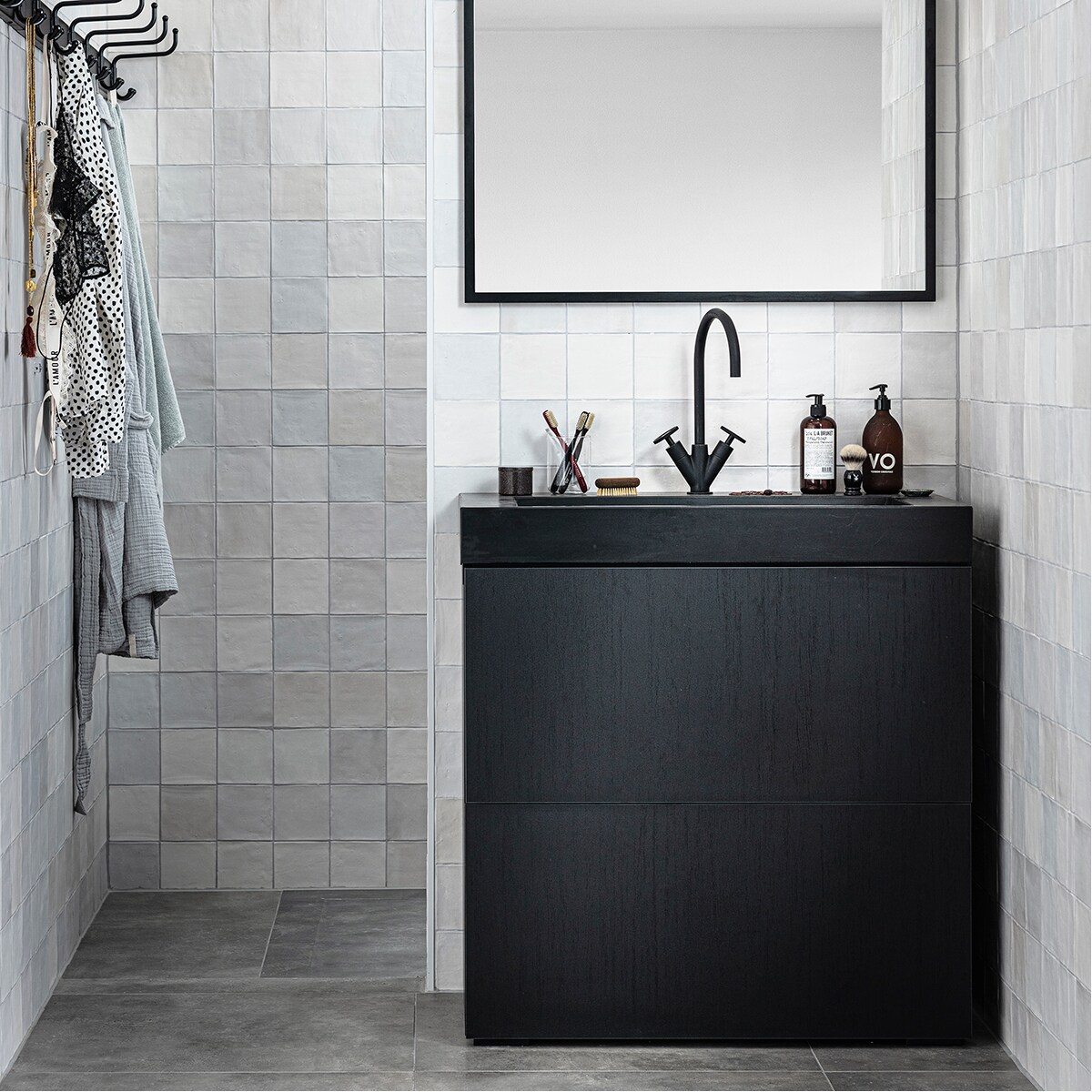 Spiegel Goodmorning met lijst in kleur Black,90×60 cm € 169,- (ook in kleur Oak), lamp voor spiegelin kleur Black, per stuk € 96,-, onderbouwkast Cubevan eikenfineer in kleur Oak Black, 2 lades,84x90x43,5 cm (hxbxd) € 739,- (ook in kleur Oak),wastafel Tank met 1 kraangat, 90x46x10 cm (bxdxh),in kleur Concrete Black € 969,- (ook in kleur Concreteen White en in diverse formaten), tweegreepswastafelkraan Flame in kleur Charcoal € 612,- (ookin kleuren Black Steel, Bronze, Brushed en Chrome),wandtegel Craft in kleur Egg White mat, 12,5×12,5 cmper m² € 69,70, vloertegel Mold in kleur Grit, 90×90 cmper m² € 70,50. vtwonen collectie 08-2020 badkamer