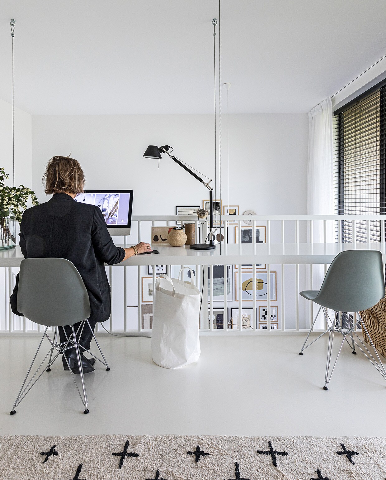 Bureau Signaal Interieur &amp; Wonen. Eames-stoelen en muismat Vitra. Vloerkleed vtwonen. Plafondlamp Teti en bureaulamp Tolomeo van Artemide. Glazen vaas Bloomon. Takken en prullenmand H&amp;M Home. PC Apple. Pennenbak Serax. Kartonnen pennenbak Harvest &amp; Co. Ornament gekocht in Frankrijk. Zwarte blinds Veneta. Gordijnen Evert Groot. vtwonen 04-2021 | styling Cathelijne Sterenberg | fotografie Sonja Velda | tekst Adeline Mans