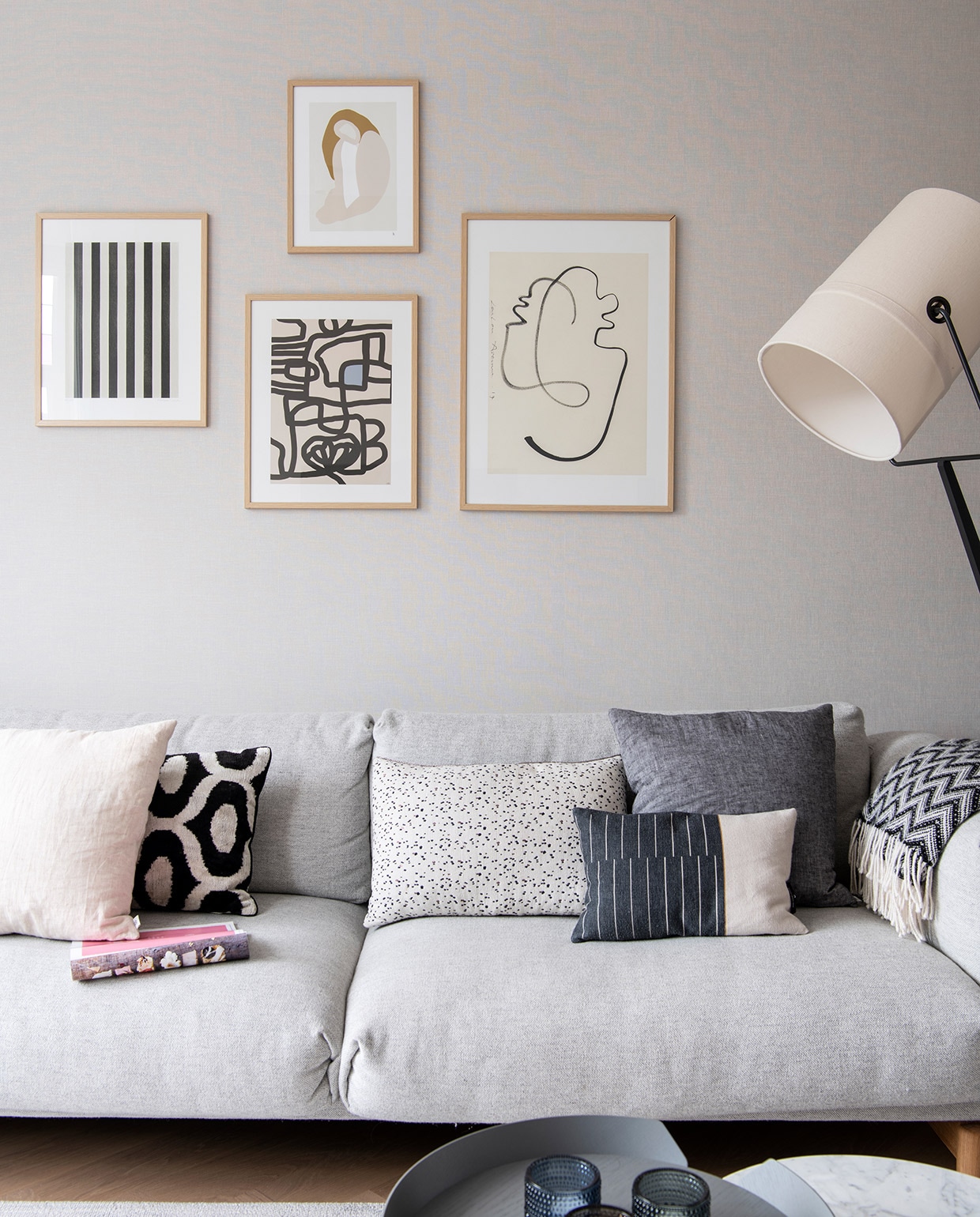 Bank Muuto. Kunst aan de muur via The Poster Club in eiken lijsten van Bolia. Kussens v.l.n.r.: wit By Mölle, wit met zwart patroon Koya Living, wit met zwarte stippen Pom, deels zwart deels wit Mae Engelgeer, antraciet By Mölle. Plaid Elvang Denmark. Waxinelichthouders Iittala. Vloerlamp Diesel. vtwonen 04-2021 | Styling Inge van Lieshout | Productie Insidehomepage | Fotografie Louis Lemaire | Tekst Inge van Lieshout | Tekstbewerking Anna van der Heijden