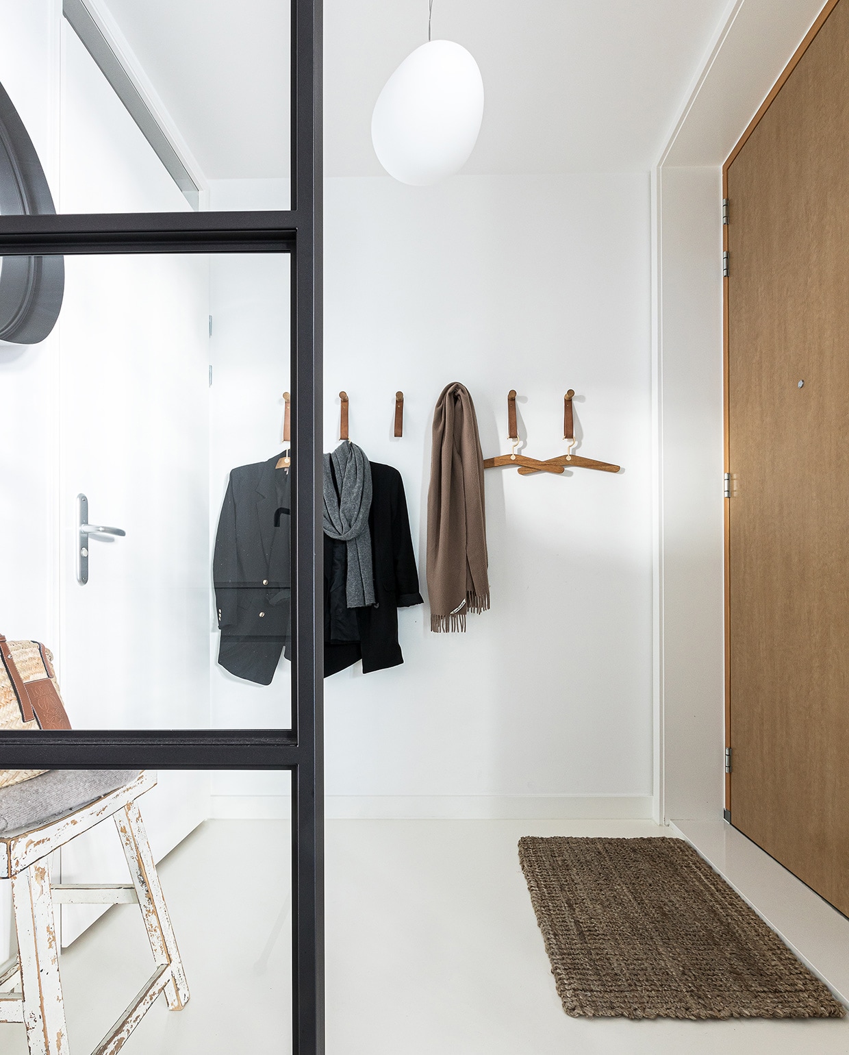 Basic interieur in de hal met witte muren en een lichtgrijze gietvloer vtwonen 04-2021 | styling Cathelijne Sterenberg | fotografie Sonja Velda | tekst Adeline Mans