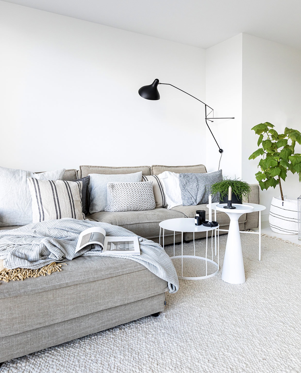 Muurverf Wijzonol ral 9016 (verkeerswit). Vloerkleed en bank Bolia. Kussens op bank Loft Loft. Grijze plaid Hay. Gele plaid H&amp;M Home. Bijzettafels, kandelaren K’willeminhuis. Bijzettafel met conische voet Zuiver. Geurkaarsen By Redo. Muurlamp DCW éditions. Bloempot Loods 5. Geweven mand Mifuko. vtwonen 04-2021 | styling Cathelijne Sterenberg | fotografie Sonja Velda | tekst Adeline Mans
