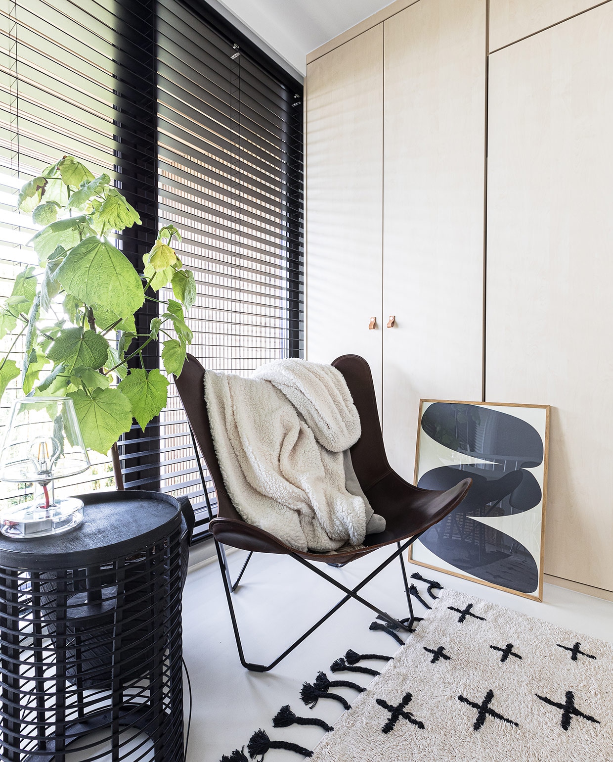 Inbouwkast op maat gemaakt Signaal Interieur &amp; Wonen. Vloerkleed vtwonen. Zwarte lantaarn als bijzettafel Yaya. Glazen lamp Fatboy. Vlinderstoel Studio Ambacht. Plaid Intratuin. Grafische print Paper Collective. Rubberen bloempot Loods 5. vtwonen 04-2021 | styling Cathelijne Sterenberg | fotografie Sonja Velda | tekst Adeline Mans