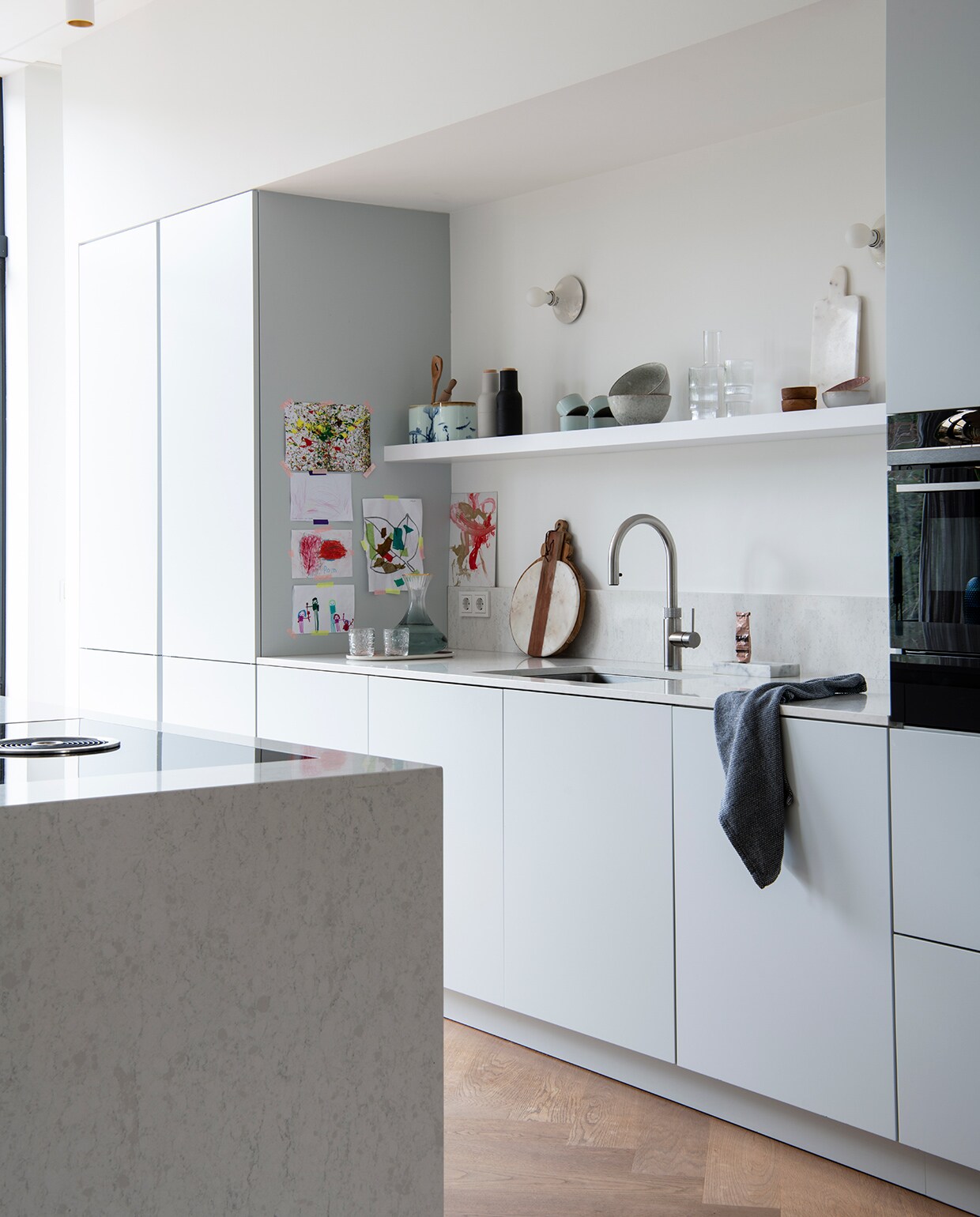 Keuken zelf ontworpen en gemaakt door Keller Keukens. Wandlamp Tom Dixon. Kraan Quooker. Broodplank Pluk Amsterdam. Marmeren zeepschaal en marmeren snijplank Stoned Marble. Theedoek, witte kommen met stipjes en houten kommen Sissy-Boy. Peper- en zoutmolen Menu. Grijze kommen Broste Copenhagen. Fles en glazen Ferm Living. vtwonen 04-2021 | Styling Inge van Lieshout | Productie Insidehomepage | Fotografie Louis Lemaire | Tekst Inge van Lieshout | Tekstbewerking Anna van der Heijden