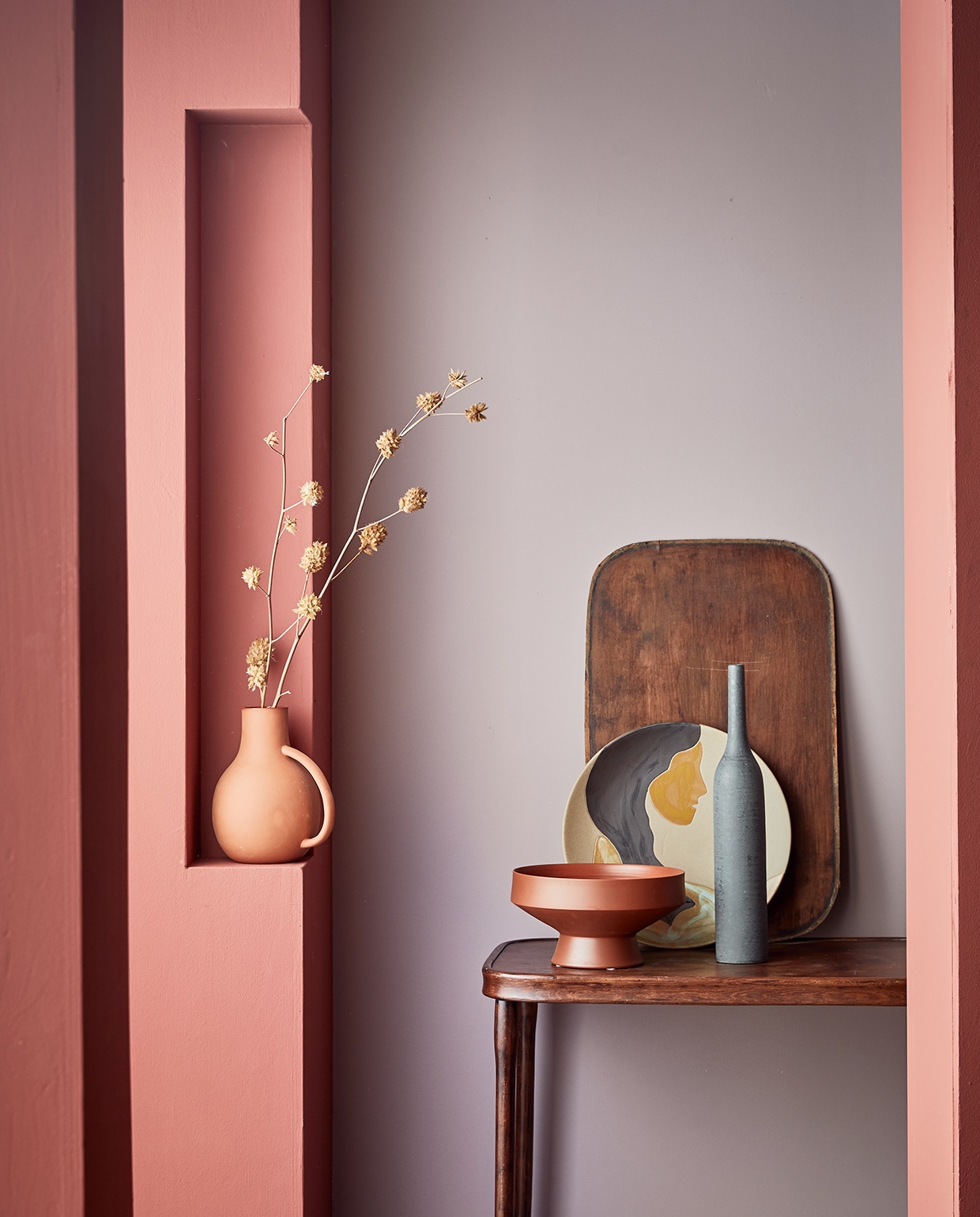 Muurverf op kolom Red Earth, op achterwand Washed Lilac.M.m.v. nordal.eu (vaas met oor, terracotta schaal) vtwonen.nl (bord met opdruk van Ferm Living). Overig privébezit. vtwonen 04-2021 | Styling Cleo Scheulderman | Fotografie Jeroen van der Spek