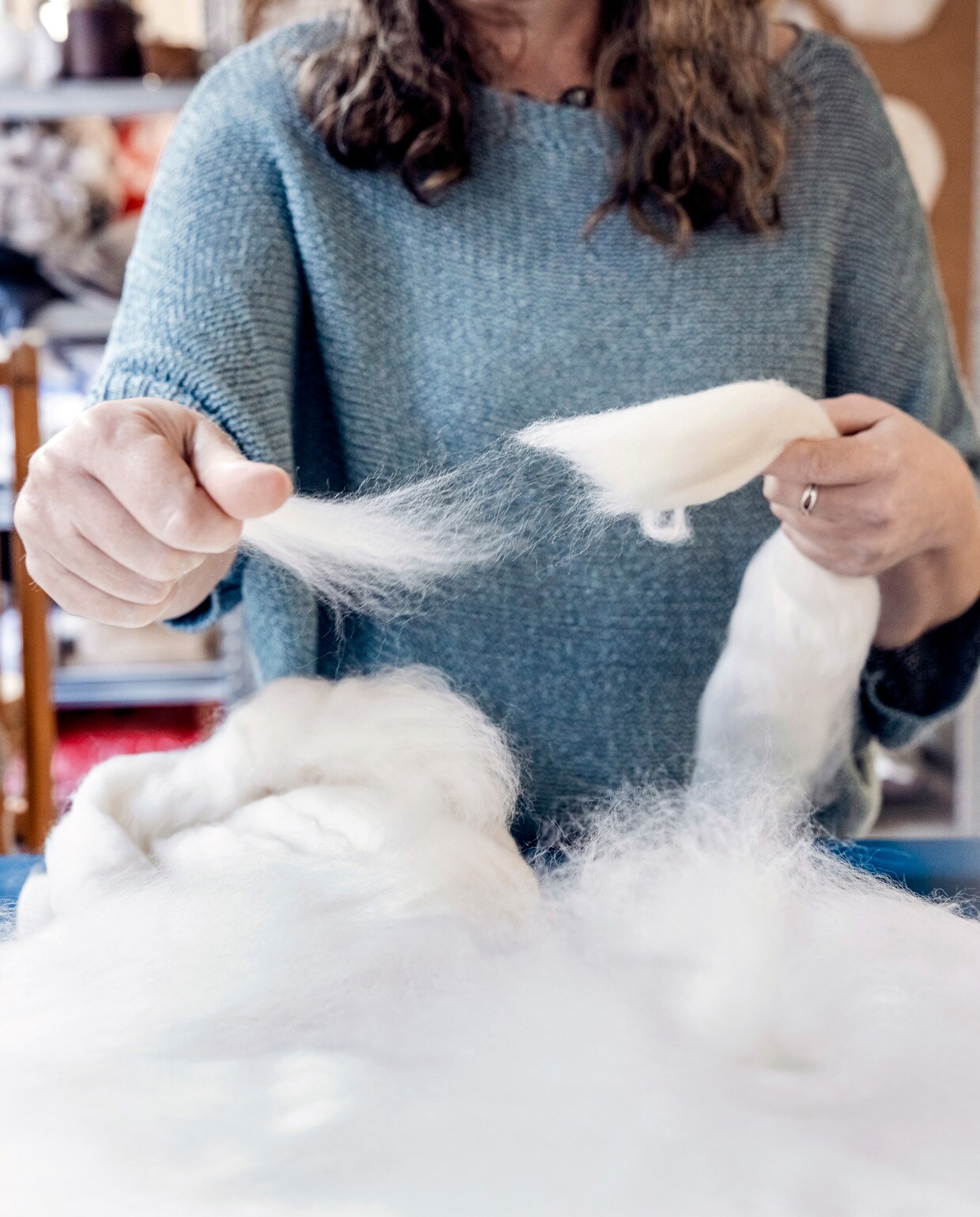 ‘Nadat ik de wol op het bubbeltjesplastic heb verdeeld, maak ik de wol nat en strijk de lucht eruit. Vervolgens rol ik het plastic op, met de wol en eventueel andere materialen ertussen. Door heen en weer te blijven rollen ontstaat vilt. De wol krimpt in de richting waarin je rolt. Als het vilt klaar is, spoel ik daarna het zeepwater eruit en laat het drogen. Dat is nog een aardige klus.’ vtwonen 04-2021 | Productie Bartjan Bouman | Fotografie Ernie Enkelaar