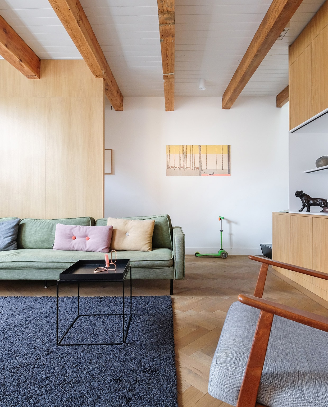 Bank Loods 5. Kussens en bijzettafel Hay. Scheerwollen kleed Marktplaats. Zwarte panter familiestuk van Oscar. Berkenhouten wandpaneel met illustratie van StoryTiles. Fauteuil Ikea. Stepje Microstep. vtwonen 03-2021 | productie Coco features | styling Gerlise van putten | fotografie Sabine Burkunk