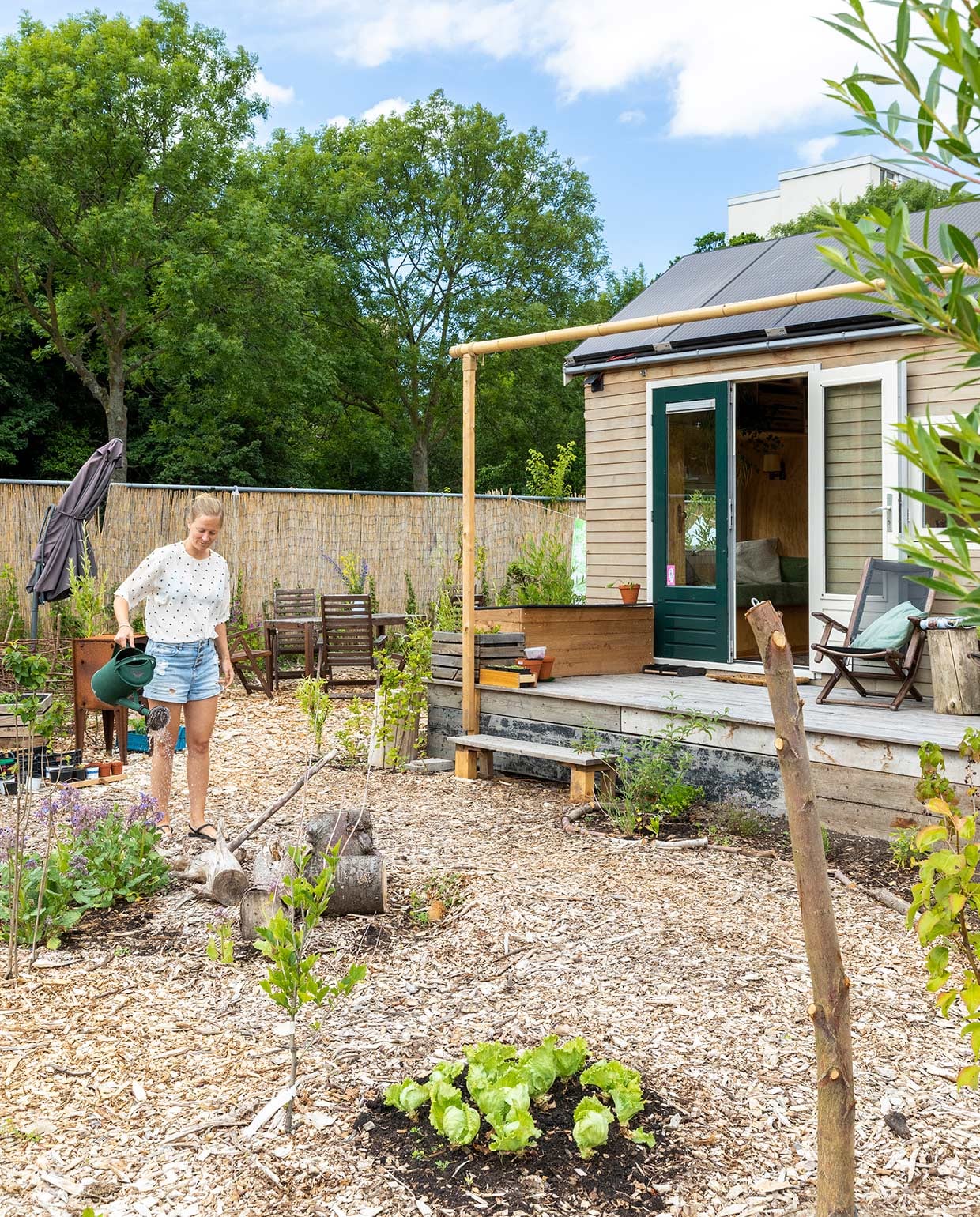 De veranda – met stoelen die het stel redde uit de vuilcontainer – kan overkapt worden met een zeildoek voor extra beschutting. vtwonen special tiny houses 2021 | Fotografie Margriet Hoekstra