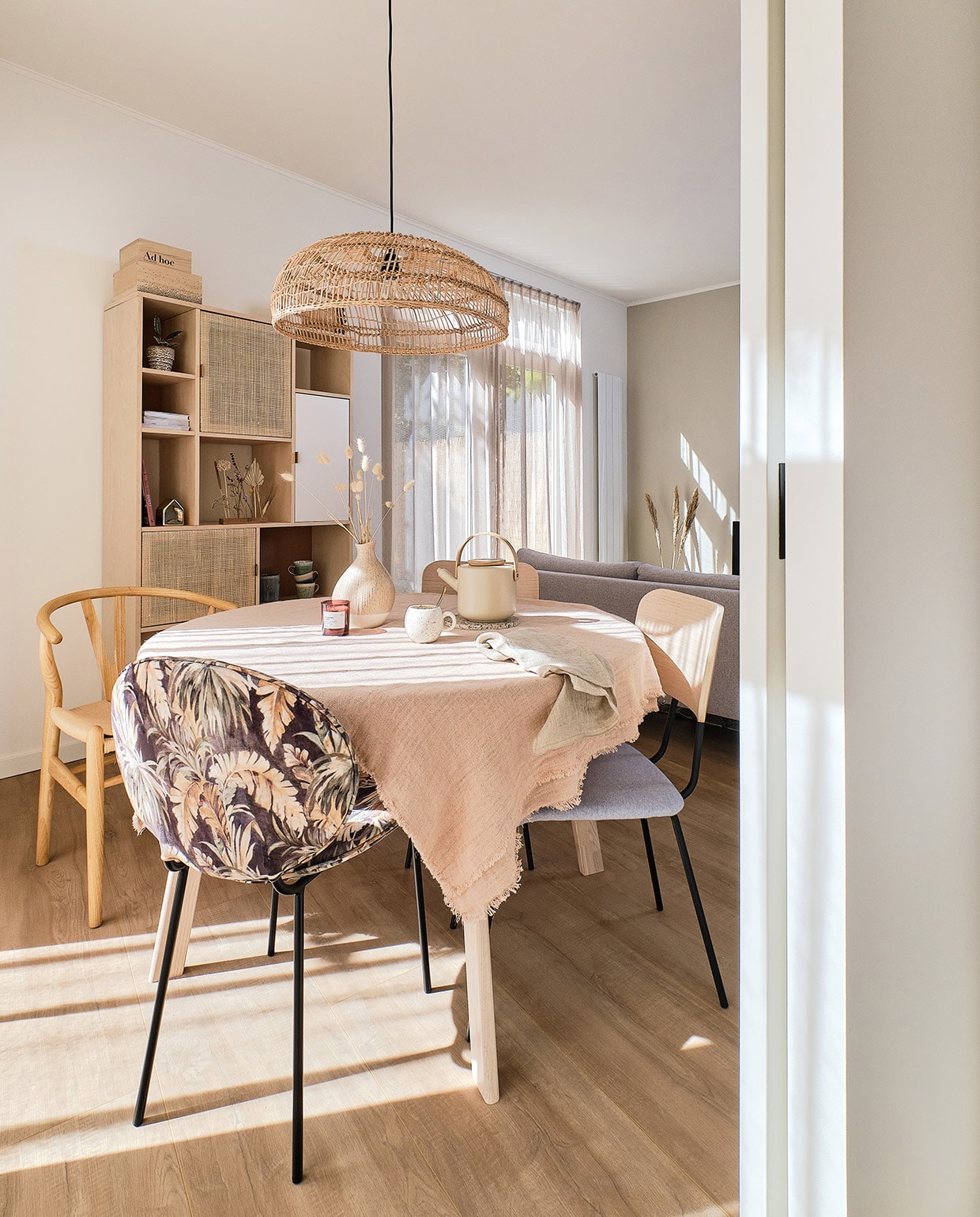 Tafel Woood. Hanglamp, tafelkleed, wijnglazen en servies HKliving. Houten stoel Sklum. Stoffen stoel Kwantum. Theepot Stelton via fonQ. Vaasje Jysk. Kast Maisons du Monde. Kistjes Bloomingville. Plant in pot fonQ. Cirkelvaas H&M Home. Huisje Bloomingville.