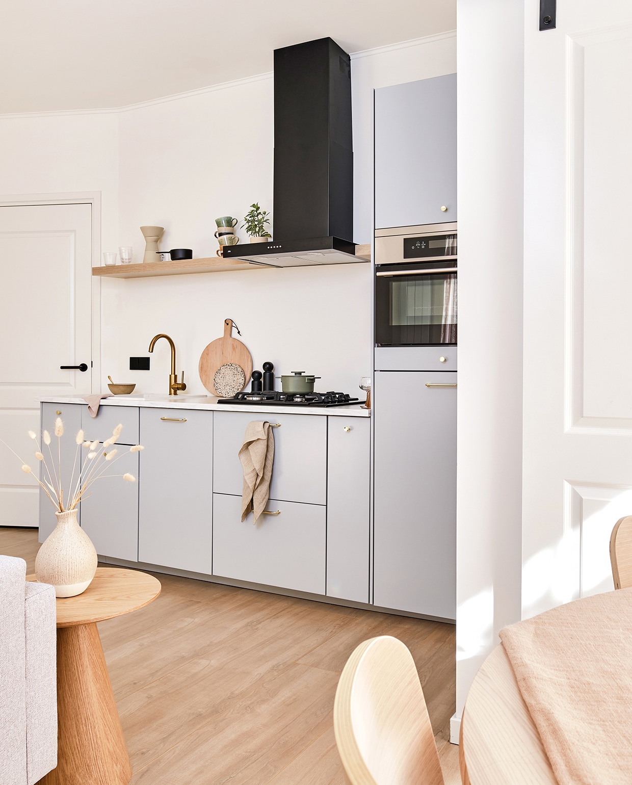 Keuken en oven Ikea. Afzuigkap en kookplaat ATAG. Kraan Karwei. Houten planken Hema. Koffiemaker Stelton. Zwarte steelpan Serax. Kopjes HKliving. Speaker Sonos. Soepkom HKliving. Vaatdoeken Zone Denmark. Terrazzo serveerplank HKliving. Peper- en zoutmolen Salt &amp; Pepper via fonQ. Theedoek vtwonen. Groene pan Serax. Schaaltjes en wijnglazen HKliving. Kleed H&M Home. Rieten stoel Leen Bakker, kussen HKliving. Bijzettafel Moos via fonQ. Kopjes Bloomingville. Bordje Serax. Rieten poef Maisons du Monde. Kussen op bank H&M Home. Vaasje Jysk.  vtwonen special tiny houses 03-2021 | fotografie Roos Oosterbroek Draw studio 24