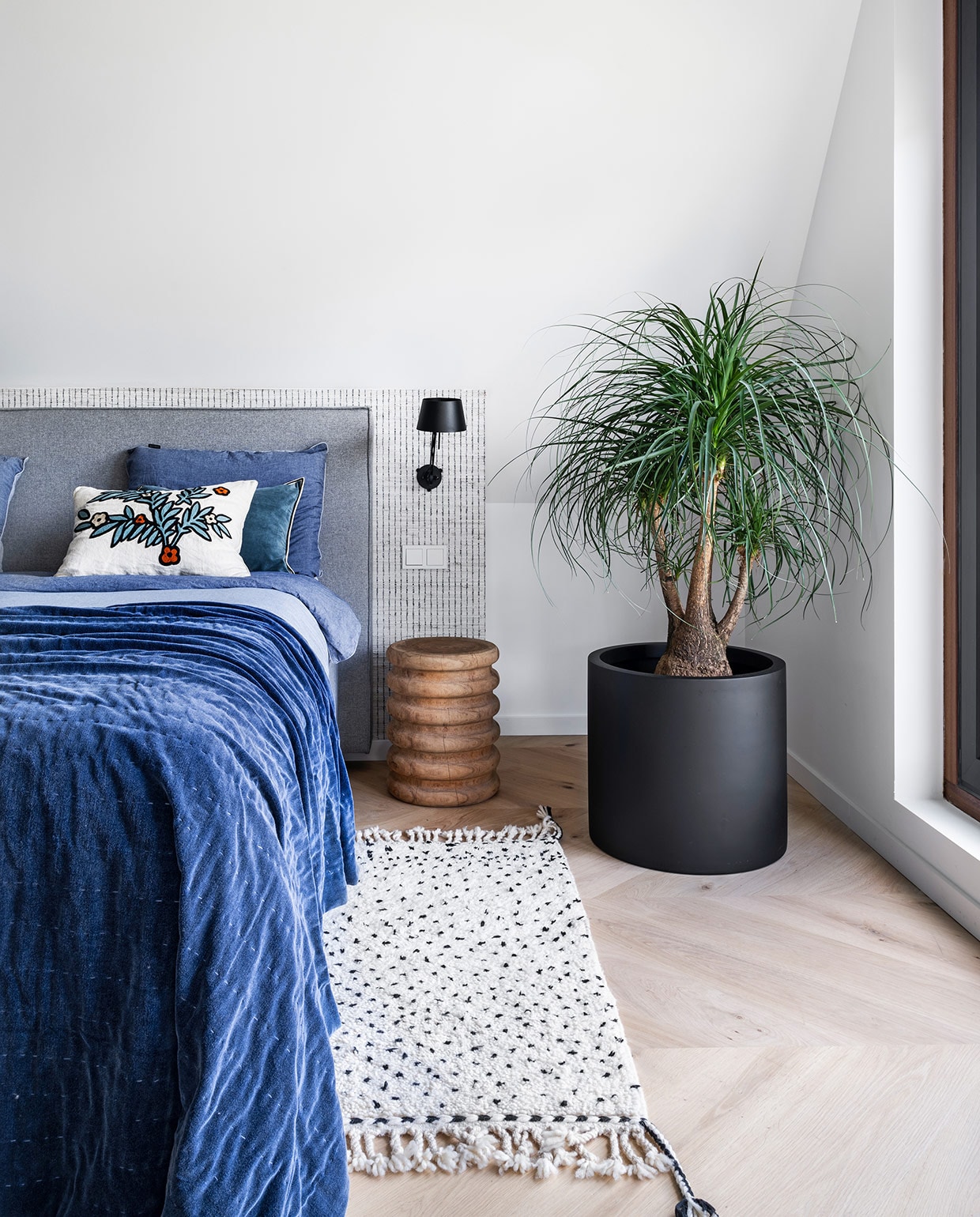 Boxspring Jac Nota, vloer eiken parket in Hongaarse punt gelegd door TB vloeren, nachtkastje Ibiza Outdoor, plantenpot Mischa Hulshof Bloembinder, vloerkleed Dots Benio, beddengoed Marco Polo, plaid Aai, sierkussens Élitis, lamp Tonone Bolt Wandlamp Side Fit, behang achter bed Sutton Stripe Thibaut. vtwonen 03-2021 | productie CocoFeatures | styling Wendy Verhaegh | fotografie Stan Koolen