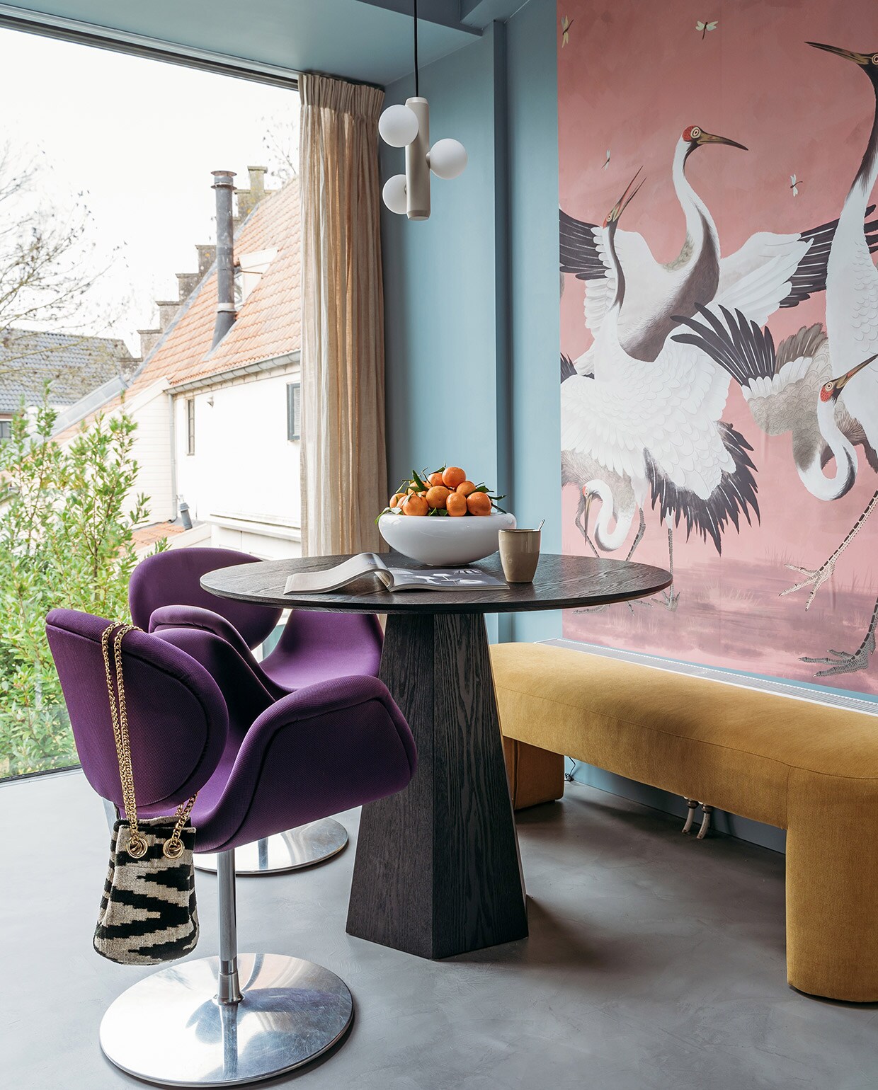 Verf muur en plafond R0.10.60 van Sikkens. Herkomst linnen gordijnen onbekend. Behang Heron Removable Peel and Stick Mural van AmsterdamElement. Tafel Pilar van Zuiver. Bank Lobby Bench van HKliving. Stoelen Little Tulip van Artifort via Marktplaats. Fruitschaal Eva Solo. Schaal Smiley van Tools Design. Beker Xenos. Hanglamp Kaktee van Fést. Tas Rough Studios. Vloer Cem-Line Micro van Loos Betonvloeren. vtwonen 03-2021 | Productie Coco Features | Styling Laurien Deken | Fotografie Inge Korver | Tekst Mariska Keus