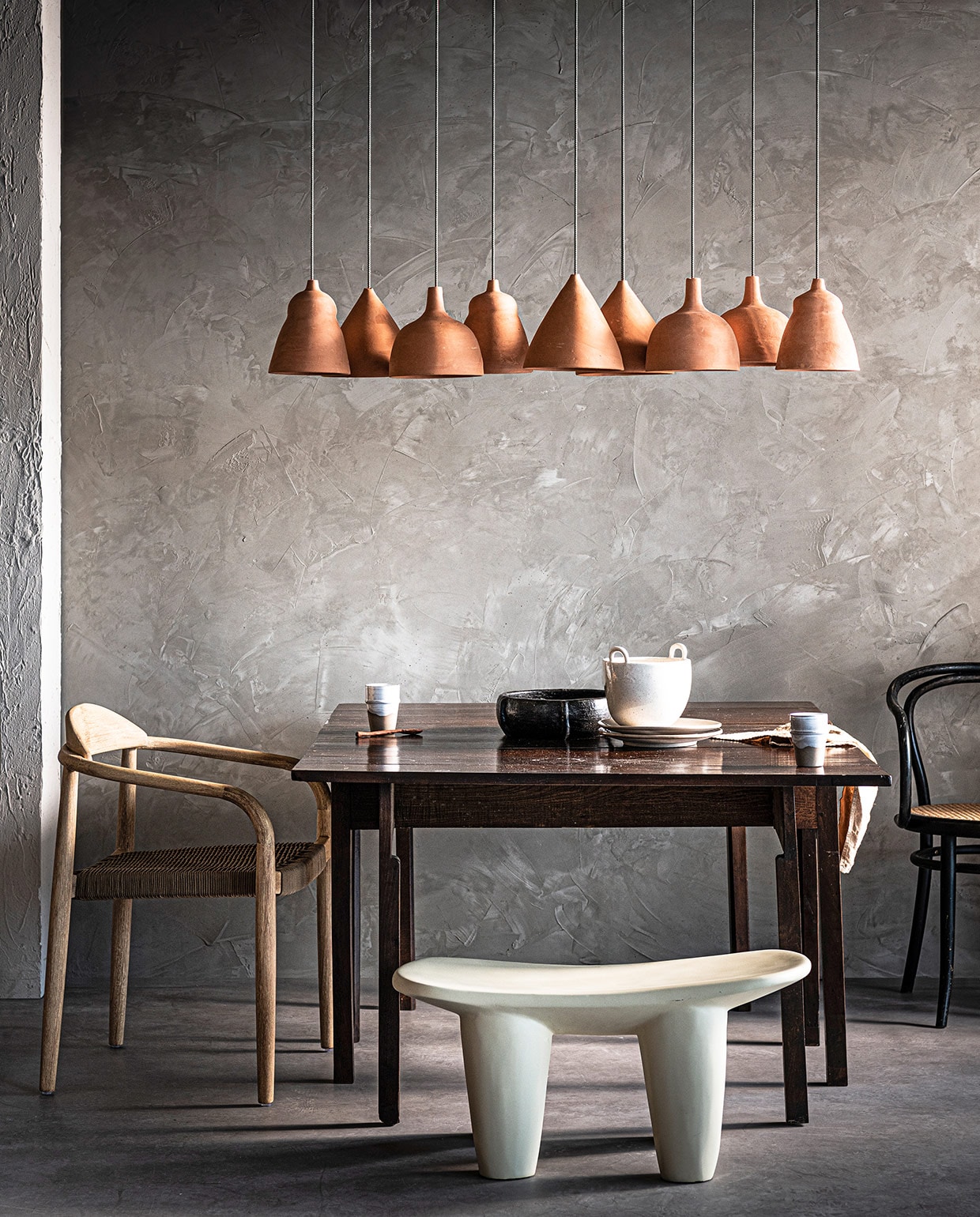 Wand bewerkt met Marrakech Walls in Dried Clay (pure-original.nl). Hanglampen in 3 verschillende vormen, pendel, polyester kruk African Stool in light Ivory, mokken, borden (householdhardware.nl). Antieke eettafel (burbri.nl). Stoel Nina van Kave Home (vtwonen.nl). Witte schaal Speckle Pot (fermliving.com). Zwarte schaal Ran, camel-kleurig linnen servet van Linge Particulier (couleurlocale.eu). Zwarte stoel privébezit. vtwonen 03-2021 | Styling Marlies Does | Fotografie Sjoerd Eickmans