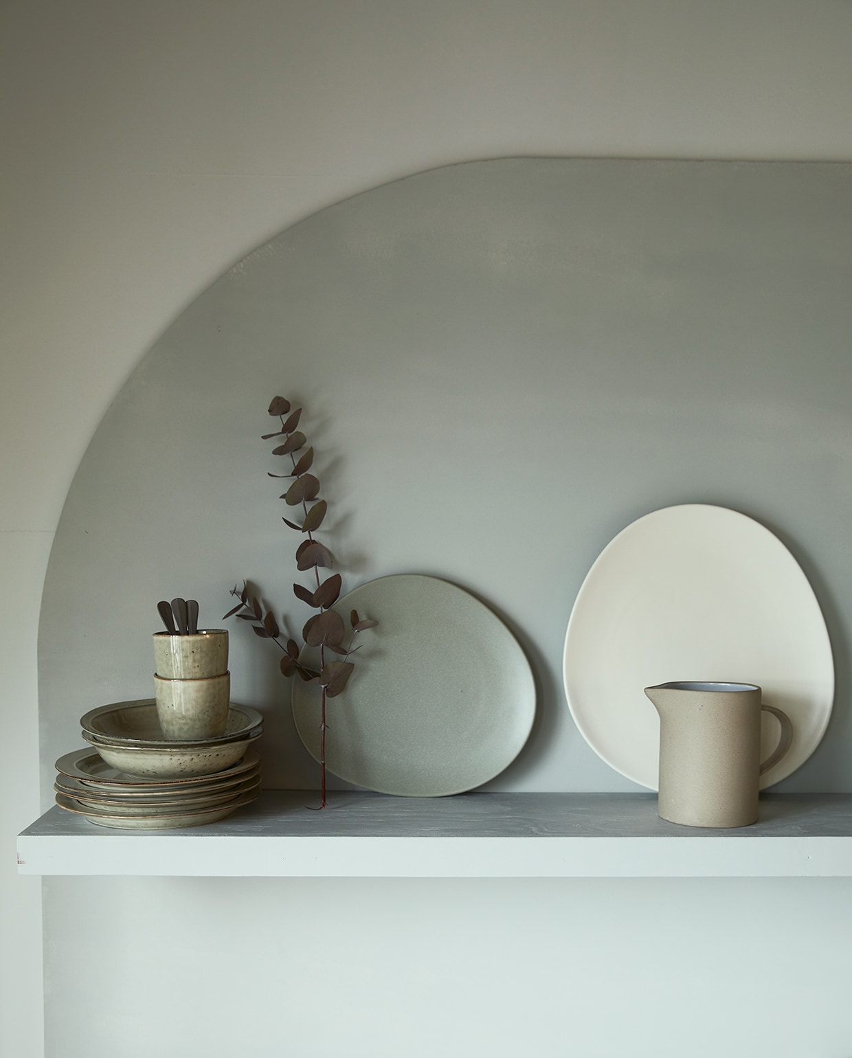 Muurverf op wand Glass, op boogvorm Wave.M.m.v. com-anders.nl (op maat gemaakte wandplank), iblaursen.nl (stapel borden, bekers, rechtopstaande keramieken borden, keramieken kan). vtwonen 04-2021 | Styling Cleo Scheulderman | Fotografie Jeroen van der Spek