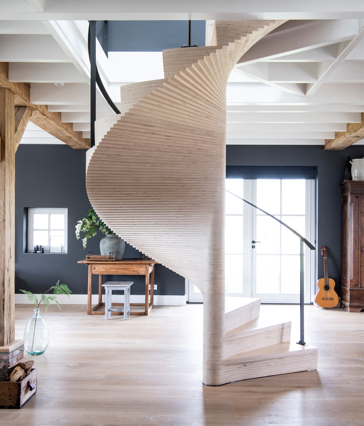 &gt; Licht eiken plankenvloer in drie breedtesDennebos Flooring, trap ontworpen door Buro Loggein samenwerking met Westenwolf Trappen.Balkenconstructie oude onbehandelde eiken balkenFrank Pouwer, vazen Tica, verf op de muur PersianGrey van Painting the Past. Bijzettafel, aardewerkpotten, kist met houtblokken rommelmarkt, gitaarResonata, kruk Stapelgoed, kast antiekwinkel. vtwonen 13-2020 | Productie Insidehomepage | Styling Marlies Does | Fotografie Louis Lemaire | Tekst Cathelijne van Wingerden \n\nBinnenkijken | vtwonen 13-2020