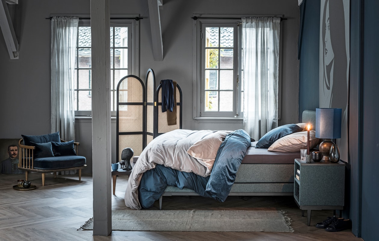 Boxspring Pepper in stof Tweed kleur Moss Green en poten Angle in kleur antraciet, 140×200 cm (bxl). Nachtkastje Cumin met stof Tweed in kleur Moss Green en poten Angle in kleur antraciet, 45×45 cm.M.m.v.: vtwonen collectie (vloerkleed, dekbedovertrekken en gordijnen), &amp;Tradition (fauteuil), Pols Potten (dienblad, glas), Wildschut Antiques (schilderij), HK Living (kamerscherm, houten hoofd, tafellamp met blauw kap), Norr11 (houten bank). Overig privébezit.
