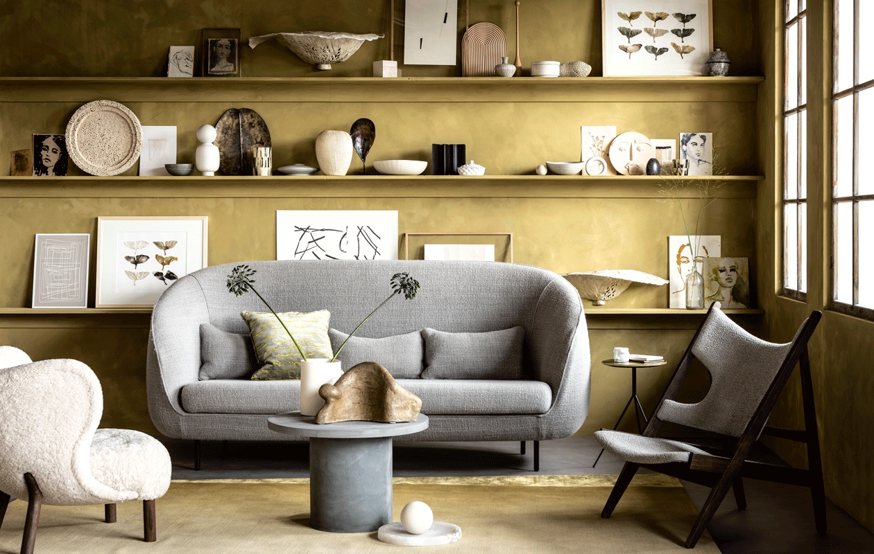 Muurverf kleur Seagrass (bauwerkcolour.com). Vloer Novilon kleur Beton van vtwonen, 200 cm of 400 cm breed exclusief installeren (vtwonen.nl/verkoopadressen). Witte fauteuil, kussen (mobilia.nl). Bank Haiku van Fredericia, 228x88x104 cm (bxdxh), houten fauteuil met gestoffeerde zitting Knitting Chair, ronde marmeren schaal Circular bowl van Menu (designtales.nl). Vloerkleed, bijzettafel driepoot witte cilindervaas, witte bol (covanderhorst.nl). Ronde betonnen salontafel van House Doctor (vtwonen.nl). Beeld van Dominic Lansen, (coosdewitwonen.nl). Witte porseleinen mok met gezicht van Gloria Landenberger (studiosomee.com). Op de bovenste plank: geschilderde schetsen en schilderijen, (tinystories.nl). Kunstobject in zwamvorm gemaakt van moerbeipapier, wandobject met gekleurde ginkobladeren van moerbeipapier in lijst (elsavisser.com). Eikenhouten lijst, vaasje (letoile.store). Poster Deconstructed no. 34, 29,7×42 cm (ateliercphshop.dk). Houten plank in regenboogvorm van Hay (vtwonen.nl). Ronde porseleinen opberger met deksel, beige object met bruine vlekjes (loods5.nl). Zwart beschilderde porseleinen pot met deksel (maisonnl.com). Kegel privébezit. Op de middelste plank: geschilderde schetsen, schilderijen en collages (tinystories.nl). Witte ronde stenen schaal, grijze craquelé kom met witte streep, witte schaal witte craquelé schaal (covanderhorst.nl). Witte vaas met ronde bol, lichtgrijze houten cirkel van Hay (vtwonen.nl). Dienblad in vorm van blad, hoge waxinelichthouder in zwart en parelmoer, zandkleurige vaas met gestreepte textuur, schelp op statief, lage waxinelichthouder met kleurschakeringen van zwart en parelmoer (loods5.nl). Zwart object en opberger Wave (coosdewitwonen.nl). Wit porseleinen schaaltje met deksel (maisonnl.com). Rond keramieken masker van Gloria Landenberger (studiosomee.com). Op de onderste plank: poster Deconstructed no. 43, 29,7×42 cm, poster Deconstructed no. 31, 50×70 cm poster Object blanc no. 25, 40×30 cm (ateliercphshop.dk). Lijsten van wit en blank eikenhout (letoile.store). Wandobject van moerbeipapier met gekleurde ginkobladeren in lijst (elsavisser.com). Geschilderde schetsen, schilderijen en collages, (tinystories.nl). Overig privébezit. vtwonen 11-2019 | Styling Danielle Verheul | Fotografie Sjoerd Eickmans