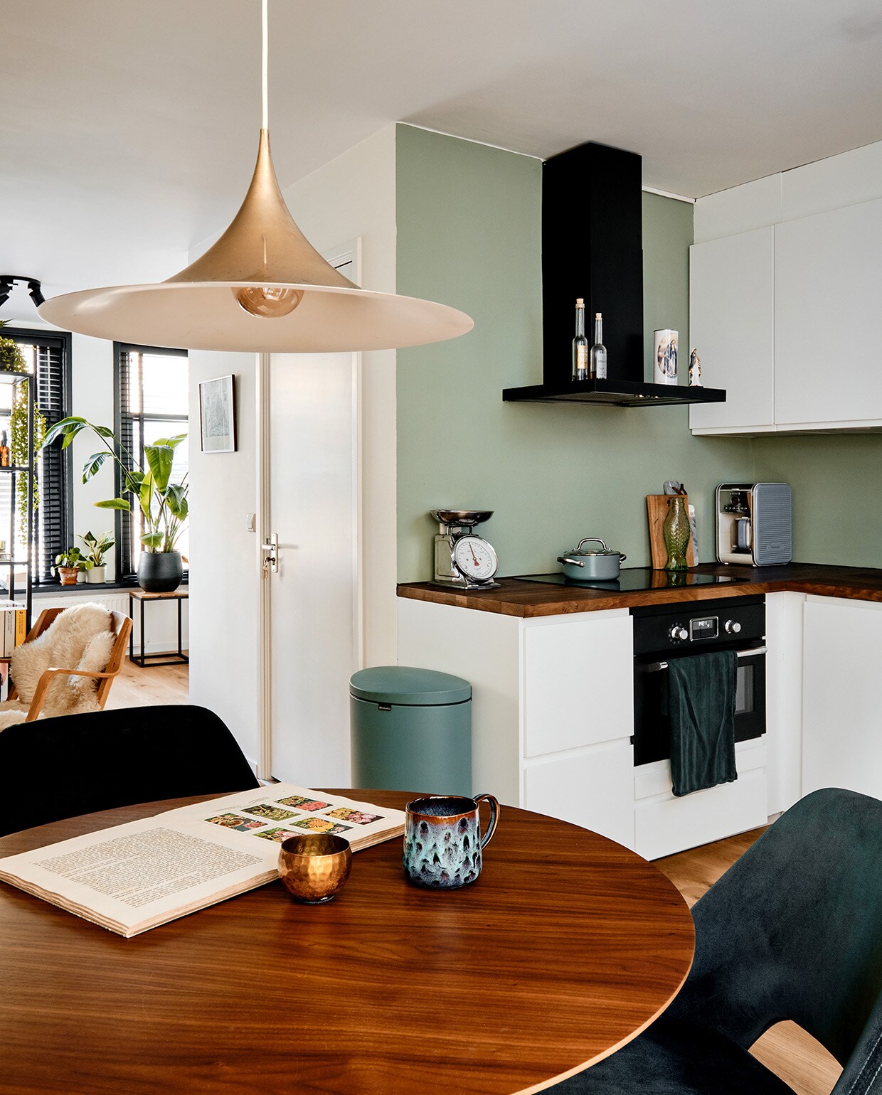 Eettafel en stoelen Loods 5, theepot Arzberg, mok kringloop. Stoel tweedehands. Plafondlamp, schapenvacht , vakkenkast en keuken Ikea. Prullenbak Brabantia, weegschaal kringloop, pan De Padova. Herkomst marmeren snijplank onbekend, houten snijplank The Maker Store. Handdoek Hema, flesjes en kaars Mondo Mediterraneo. vtwonen 02-2021 | Productie Coco Features | Fotografie Roos Oosterbroek