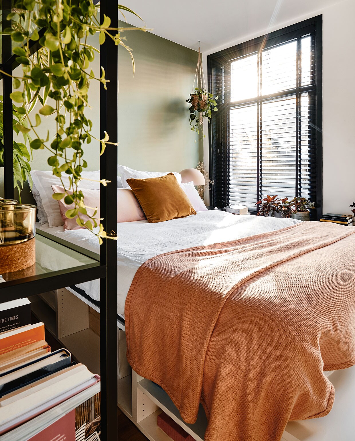 Bed, kussens en vakkenkast Ikea. Beddengoed Hema, sprei Made. Hangplant, bloempot, waxinehouders De Balkonie. Nachtlamp Made. vtwonen 02-2021 | Productie Coco Features | Fotografie Roos Oosterbroek