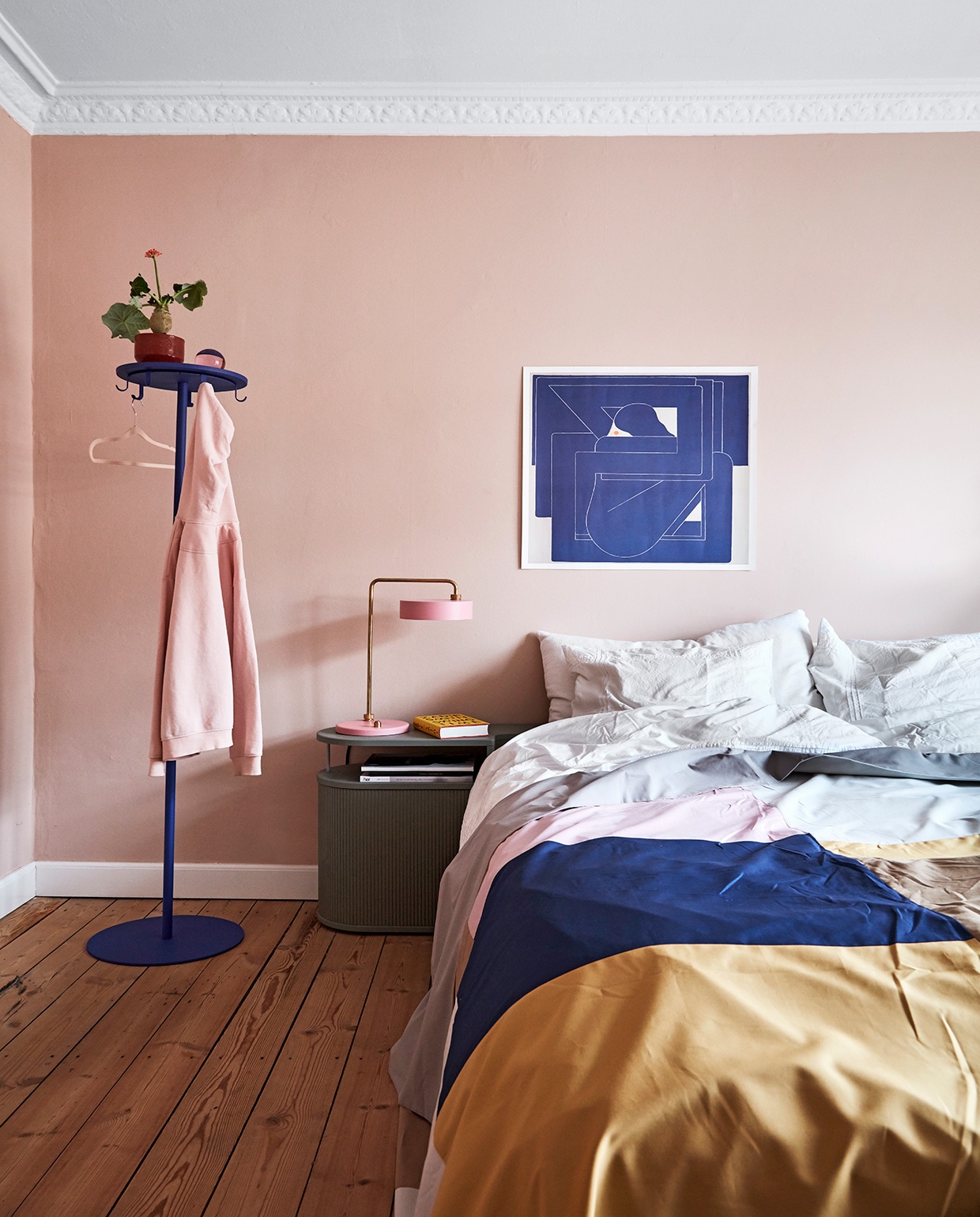 Muurverf Setting Plaster van Farrow &amp; Ball. Bed met ingebouwd nachtkastje Auronde Clay van Auping, sprei A Hint of Neon. Tafellamp Made by Hand, poster Richard Colman, kapstok Nomess, roze glazen bal Strups, terracotta pot Skagerak. vtwonen 02-2021 | Productie en fotografie Stine Christiansen | Styling Gitte Christensen