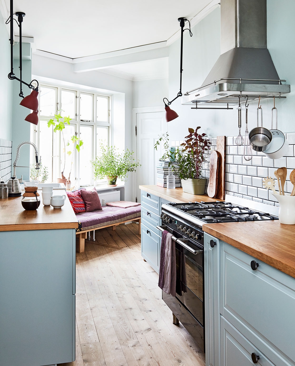 Muurverf 7555 Soft Mint van Jotun, verf kasten 7163 Minty Breeze van Jotun. Keuken was al aanwezig, fornuis Smeg, theedoek Georg Jensen Damask, Hammershøi theepot Kähler, overige keukenaccessoires Ikea, Tchibo en Georg Jensen Damask. Tegels Fired Earth en Arttiles. Daybed Nyt i Bo, kussens uit Thailand. Lampen DCW. vtwonen 02-2021 | Productie en fotografie Stine Christiansen | Styling Gitte Christensen
