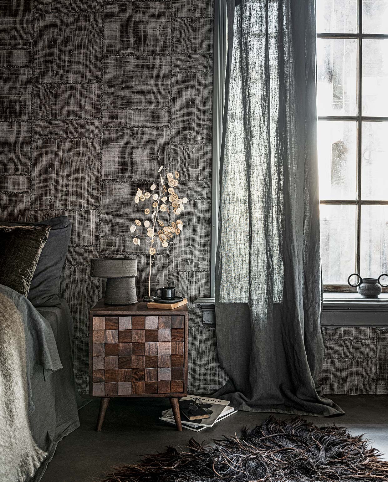 Vloer vtwonen Novilon Kwarts, 200 of 400 cm breed, per meter vanaf € 56,50 (vtwonen.nl). Behang Twine in kleur Warm Steel uit Cameo collectie, 0,70×8,5 m (bxl), per rol € 199,- (arte-international.com). Lakverf op raamkozijn Ground Pepper, per liter € 57,30 (pure-original.nl). Linnen dekbedovertrek in kleur Slate vanaf € 139,-, linnen kussensloop in kleur Slate vanaf € 28,-, mohair plaid € 199,- (bymolle.com). Grijs fluwelen kussen van William Yeoward € 96,-, gordijn gemaakt van stof Brera Lino in kleur Granite, per meter € 71,- (wva.nl). Houten nachtkastje €149,-(zarahome.com). Keramieken tafellamp €375,-, zwarte keramieken pot met dubbel handvat € 45,- (studio-yen.com). Zwarte kop en schotel € 9,99 (hm.com). Schapenvacht € 189,- (vachtvanvilt.nl). Overig privébezit. vtwonen 02-2021 | styling Danielle Verheul | fotografie Sjoerd Eickmans