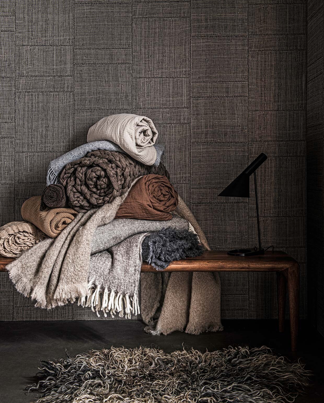 Vloer vtwonen Novilon Kwarts, 200 of 400 cm breed, per meter vanaf € 56,50 (vtwonen.nl). Behang Twine in kleur Warm Steel uit Cameo collectie, 0,70×8,5 m (bxl), per rol € 199,- (arte-international.com). Walnoothouten bank €1282,-, tafel- lamp € 790,- (kasstoor.nl). Schapenvacht € 189,- (vachtvanvilt.nl). Dekens van boven naar beneden: zachtgrijze plaid € 69,99, grijze deken met witte rafels € 29,99, bruine gehaakte deken € 49,99, beige deken met reliëf € 99,- (hm.com). Wollen deken € 89,99, bruine linnen deken € 169,- (zarahome.com). Grof wollen deken € 279,- (vachtvanvilt.nl). Beige mohair deken €195,- (coosdewitwonen.nl). Deken met visgraatprint, € 199,-, antracietgrijze mohair deken € 199,- (bymolle.com). vtwonen 02-2021 | Styling Danielle Verheul | Fotografie Sjoerd Eickmans