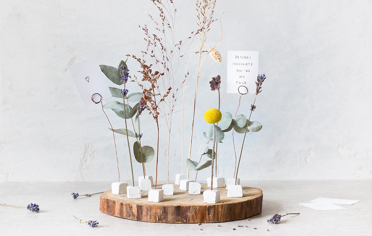 Houtschijf Paulownia Ø 25 cm € 4,25 (decoratietakken.nl). Witte boetseerklei Fimo Air, 500 g € 2,49 (ava.be). Koperdraad 0,50 mm, per 50 m € 3,25 (boerma.nl). Witte kaarten, per 100 € 14,90 (bol.com). vtwonen 02-2021 | Styling &amp; Fotografie Dorothee Dubois / The Fresh Light