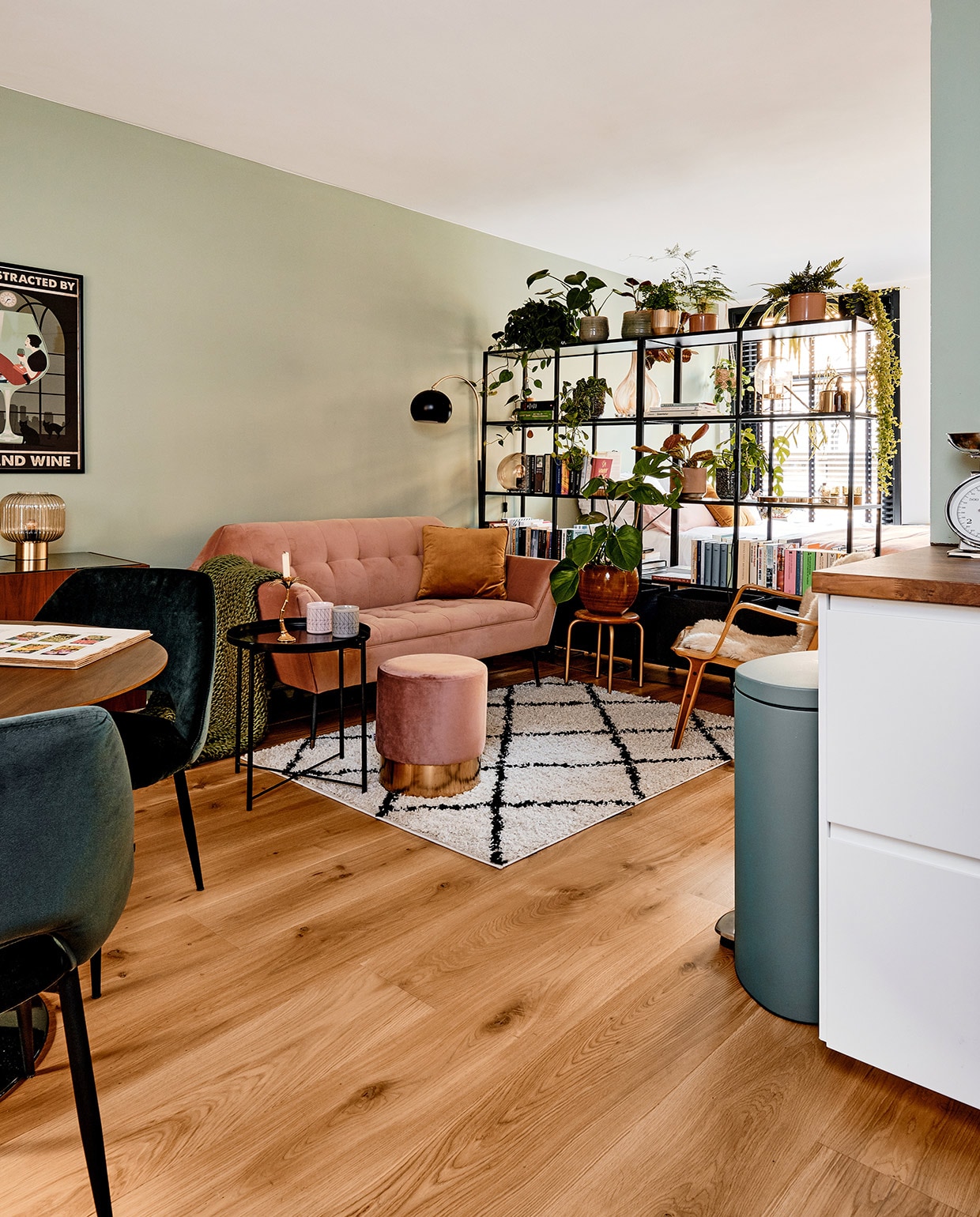 Bank en poef Home Stock. Kussen, schapenvacht, vakkenkast en zwarte bijzettafel Ikea. Kruk KidsDepot, vloerkleed Volero, vloerlamp Made, stoel tweedehands. Vaas op kruk en bloempotten De Balkonie. Vaas in vakkenkast kringloop. Prullenbak Brabantia. Muurverf Jofel van Praxis, eiken lamelparket Stox. vtwonen 02-2021 | productie Coco Features | fotografie Roos Oosterbroek