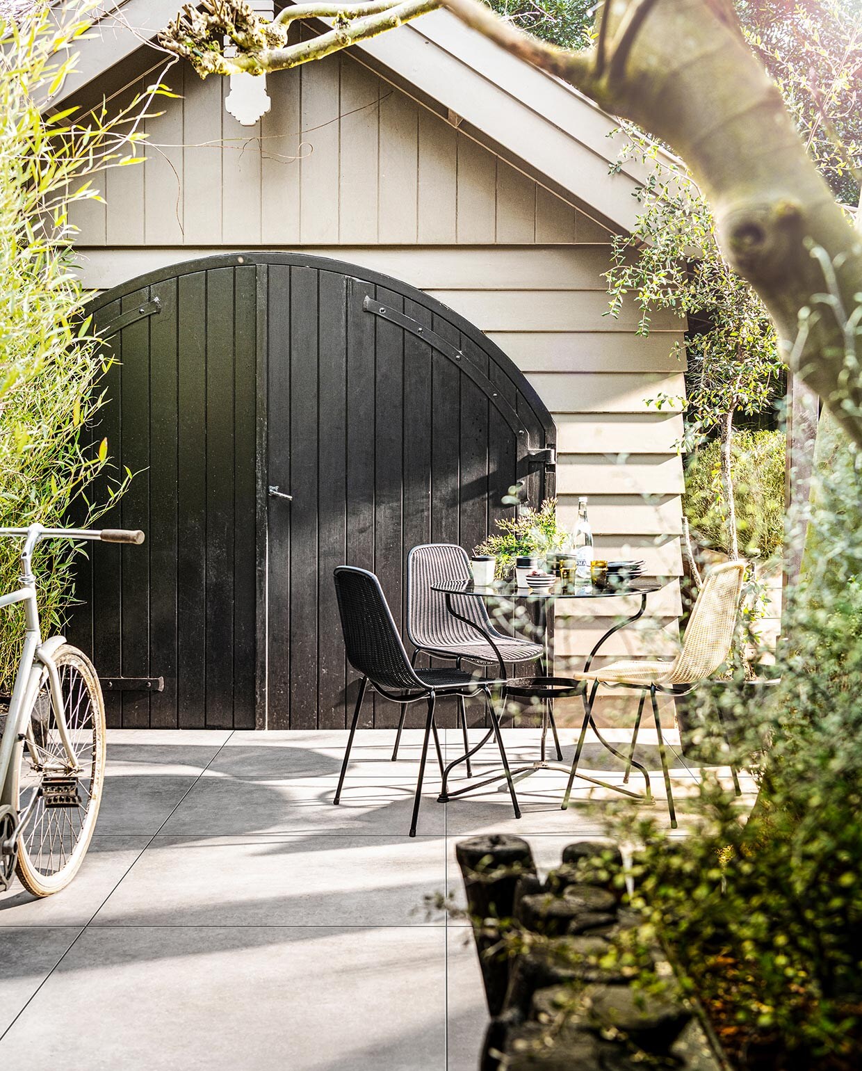 Tegels Solostone Uni Mold Grit, , 90x90x3 cm (lxbxh) (ook verkrijgbaar in Basalt, en in Grit, Basalt , en Taupe in 70x70x3,2 cm). M.m.v. householdhardware.nl (servies, mokken, glazen, schaaltje), bymolle.com (stoelen Basket Chair). Overig privébezit. vtwonen 03-2021 | Productie Tanja Saarberg | Styling Kim van Rossenberg | Fotografie Sjoerd Eickmans\n