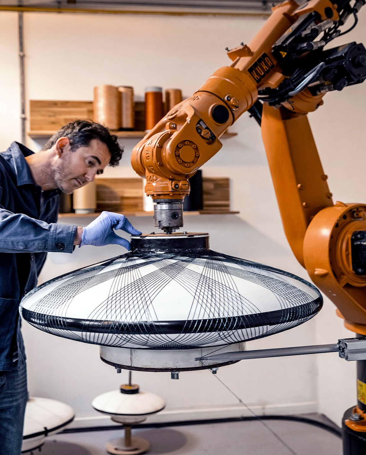 De Fiber Pattern Lamp is gemaakt van met epoxyhars geïmpregneerde vezels. De vezels worden met een industriële robot in geometrische patronen om een mal gewikkeld. Het resultaat is een lichtgewicht , en sterke lamp. Model Ufo is verkrijgbaar in diverse diameters en de kleuren Charcoal Black, Chalk White, Moss Green en Copper. vtwonen 01-2021 | Fotografie Ernie Enkelaar | Tekst Bartjan Bouman
