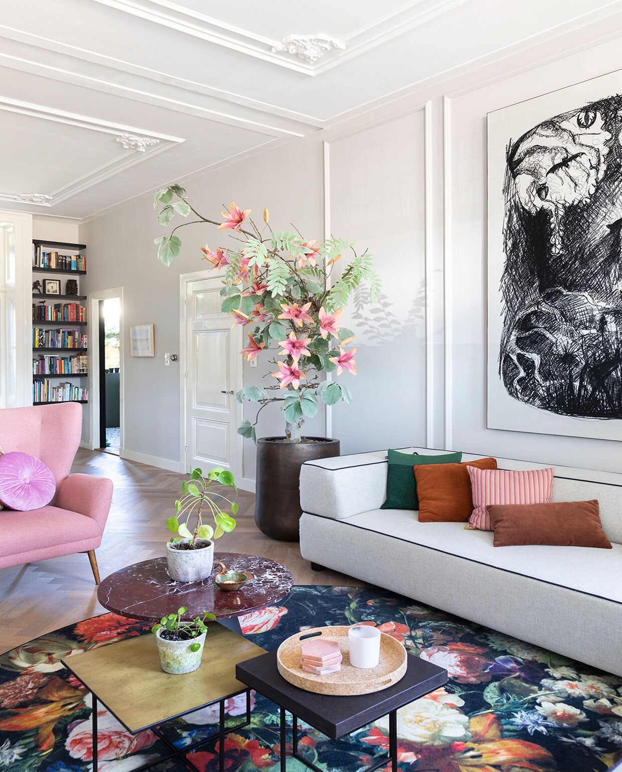 Muurverf Cornforth White, massief eikenhouten visgraatvloer via Martijn de Wit Vloeren, boom ’s Zomers Bloemen, pot Domani, marmeren bijzettafel Westwing, pot Dekatuin, schaaltje op tafel Anna + Nina. Fauteuil Sofacompany, kussens op fauteuil Essenza, wandplanken waren al aanwezig, geverfd in Pitch Black van Farrow &amp; Ball. Bank Fest Amsterdam, vloerkleed Moooi. vtwonen 01-2021 | Productie en Fotografie Margriet Hoekstra | Tekst Anna van der Heijden