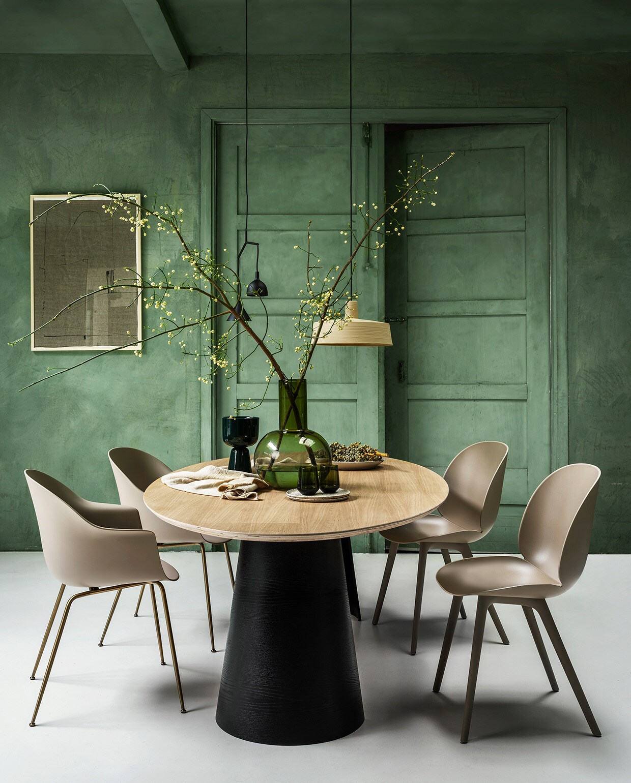 Eikenfineer tafel Arp, 260x120x75 cm (lxbxh) € 2225,- (loods5.nl). Stoelen Beetle en Bat van Gubi vanaf € 349,-, zwarte hanglamp Menu € 249,-, zandkleurige hanglamp Marset € 574,-, groene glazen vaas HKliving € 99,95, linnen tafelkleed van vtwonen € 79,95 (vtwonen.nl). Ingelijste textielkunst Fant € 495,-, keramieken borden en schaal vanaf € 35,- (sukha.nl). Donkergroene aardewerk pot op voet € 69,-, groene waterglazen per 2 € 64,90 (iittala.com). Kalkverf Lagune, per liter € 48, (cartecolori-dialma.nl). vtwonen 01-2021 | styling Marianne Luning | fotografie Stan Koolen