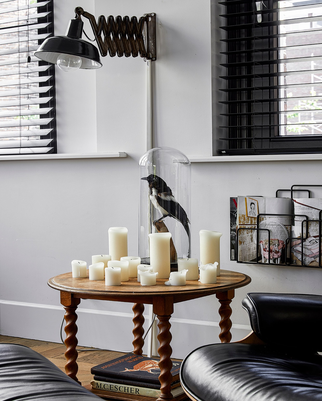 Vogel in stolp vintage pop-up store. Bijzettafel gevonden bij vuilnis. Zwarte Eames Lounge Chair Vitra. Kaarsen Hema. Tijdschriftenrek Minus-tio vtwonen 02-2021 | productie Coco Features | styling Emmy van Dantzig | fotografie Peggy Janssen