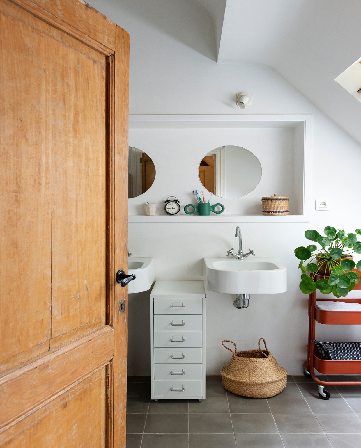 Ronde spiegels, wasbakken, kranen en vloertegels van een lokale bouwmarkt, vintage wekker, , mandje van de kringloop, ladekast, trolley en rieten mand . vtwonen 01-2021 | styling Esther Schuivens | fotografie Caroline Coehorst | tekst Chris Muyres