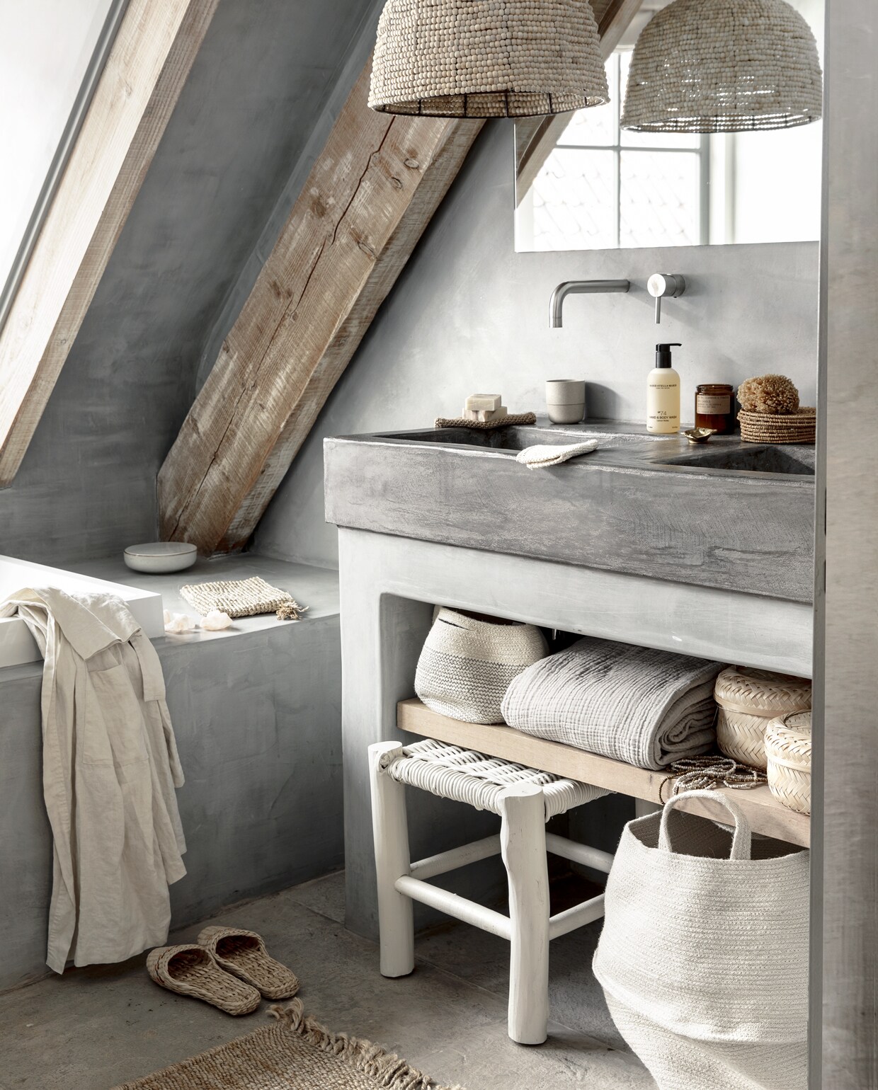 Badombouw en wanden in Marrakech Walls (pure-original.nl), wastafel in betonlook Beal Mortex, ook geschikt voor inloopdouches. Hanglamp van houten kraaltjes, schaal met deksel Broste Copenhagen, gevlochten toilettas, Himalayazout, zeep, scrubdoekjes, beker, hand &amp; bodywash Marie Stella Maris, sojageurkaars, sisal vloerkleed Bloomingville (loftloft.nl). Ronde doos van gevlochten palmblad, bamboe manden klein, groter (sostrenegrene.com). Natuurspons (dille-kamille.com). Kleine katoenen opbergmand, grote katoenen wasmand, wafeldoek, naturel linnen ochtendjas (hm.com). Houten kruk (privébezit) geverfd met krijtlak in de kleur Madonna (cartecolori.nl). JA | vtwonen special 03-2019 | Fotografie Peggy Janssen | Styling Moniek Visser