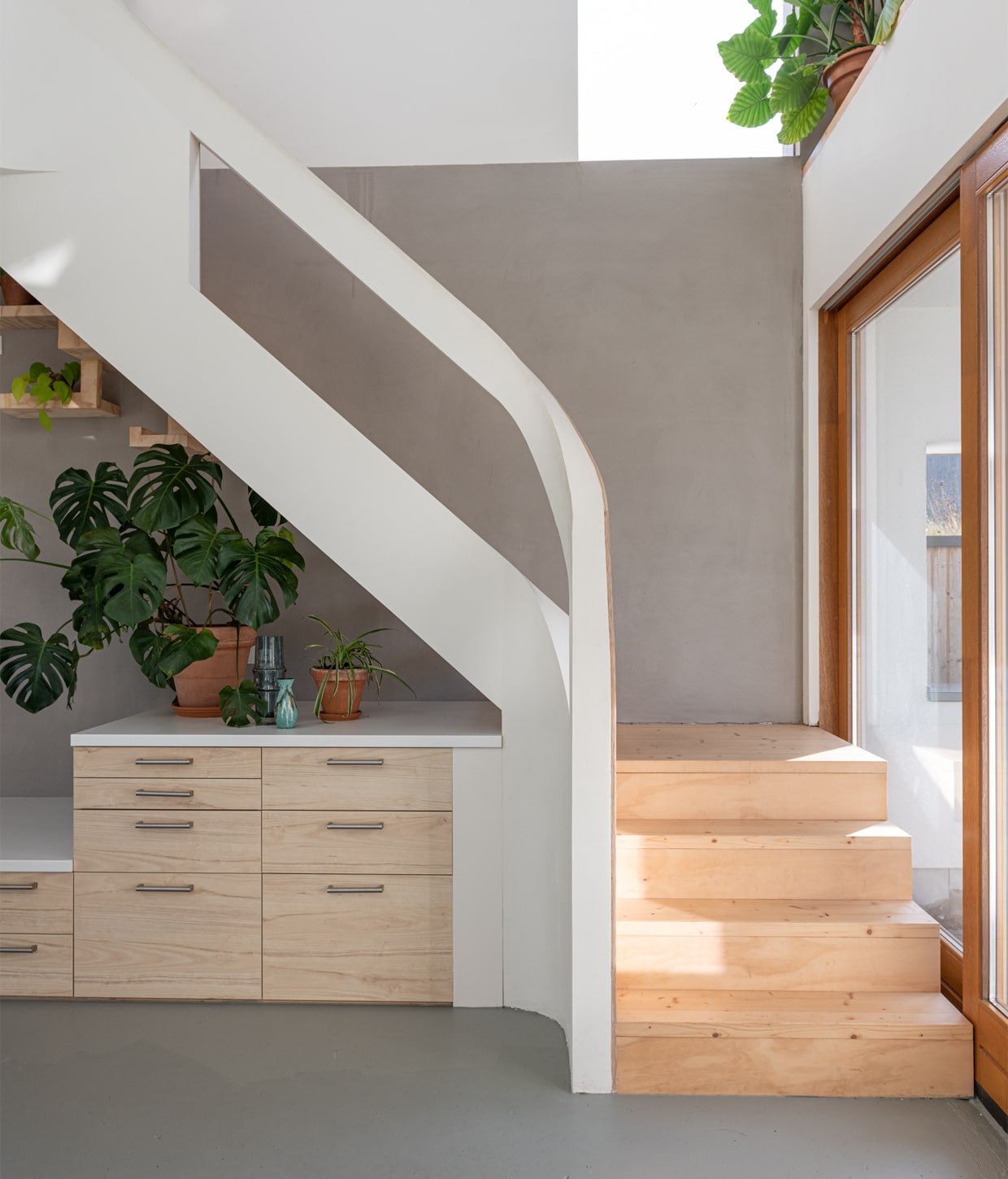 Zandcementdekvloer met vloercoating, trap en houten muren van vurenhout en radiplex. vtwonen 01-2021 | Productie en fotografie Caroline Martinot | Styling Sharon Roest