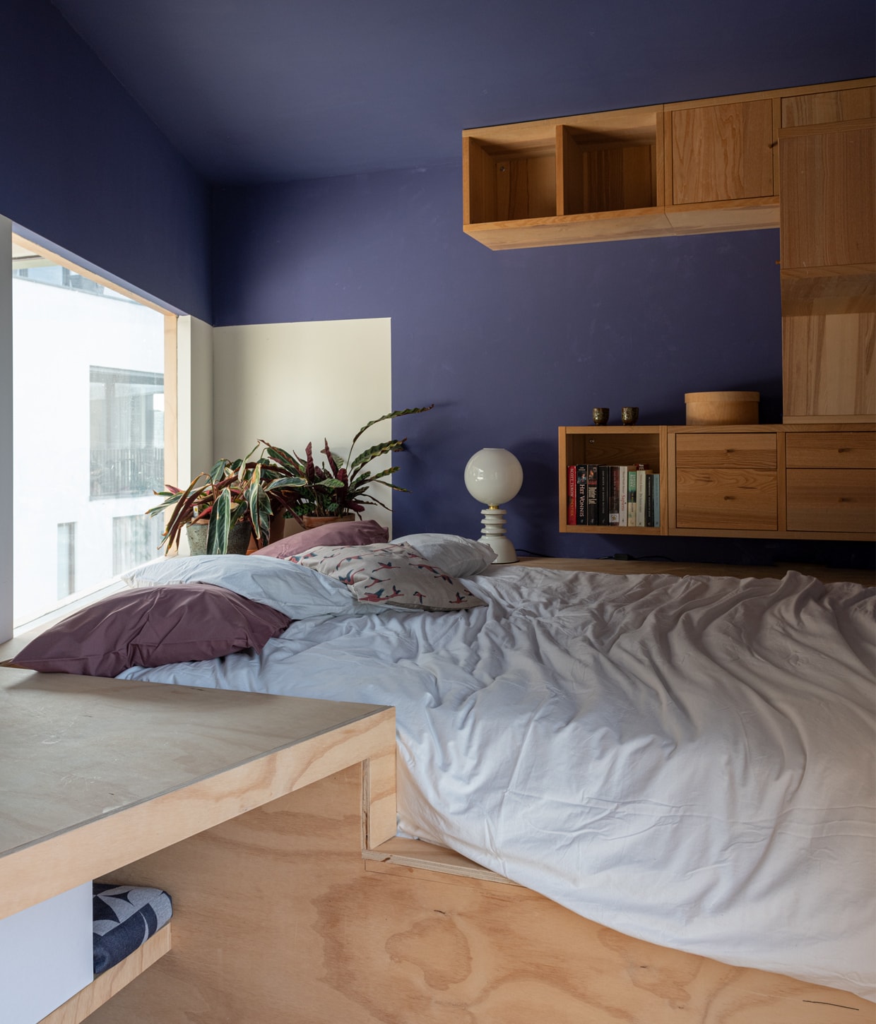 Muurverf paars Praxis, wandkast componenten Ikea, tafellamp Vintkracht, wit en paars beddengoed Ikea. vtwonen 01-2021 | Productie en fotografie Caroline Martinot | Styling Sharon Roest