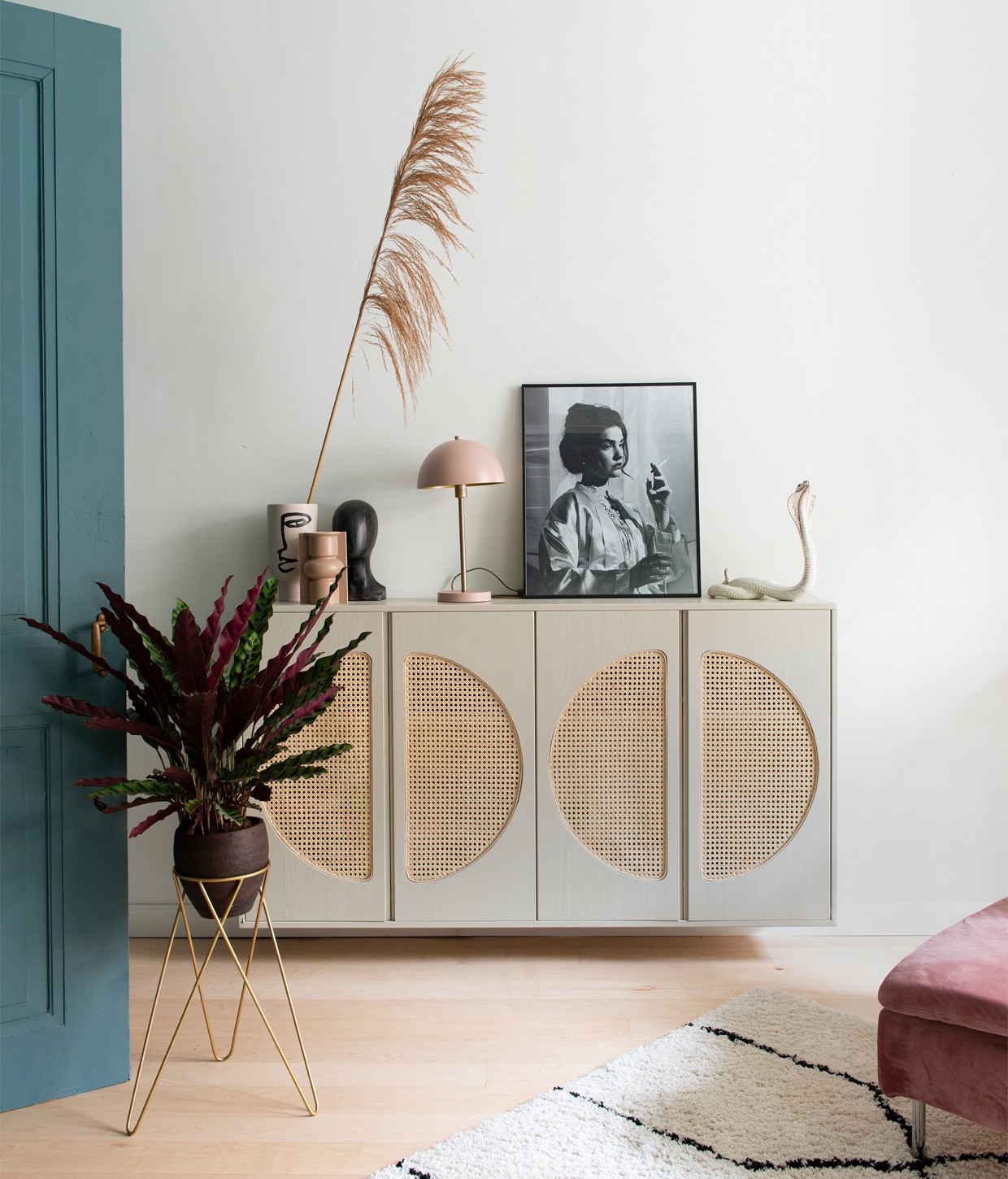 Kast Ivar van Ikea, zelf cirkels uitgefreesd en met pitriet omgebouwd tot webbingkast, geverfd met Drop Cloth van Farrow &amp; Ball. Vaas gezicht H&amp;M Home, voorste vaas en object gezicht HKliving. Lamp Rietveld Licht. Portretfoto van buurjongen gekregen. Beeld cobra vintage vondst. Plantenstandaard Sissy-Boy, plant Calathea. Vloerkleed Karwei, bankhoes Norsemaison. Verf deur Inchyra Blue van Farrow &amp; Ball, muurverf verkeerswit Ral 9016. vtwonen 01-2021 | styling Jeske Weel | fotografie Caroline Coehorst
