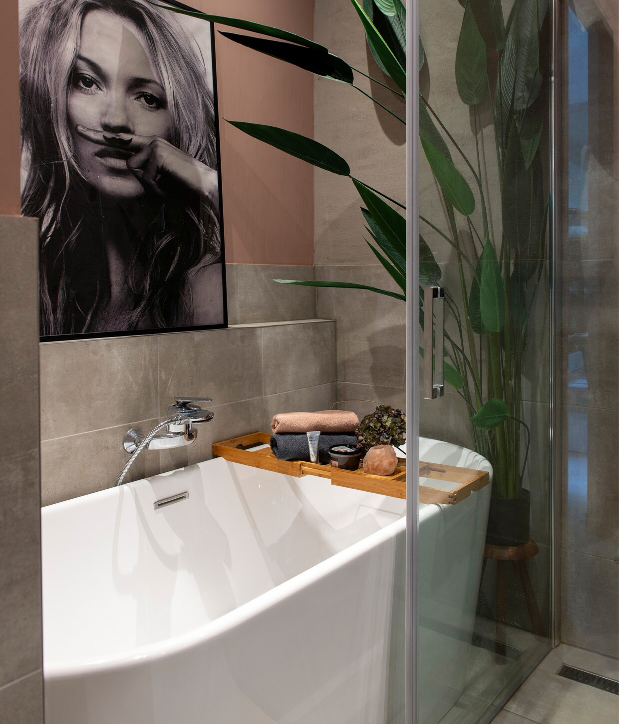 Muurverf Sulking Room Pink Modern Emulsion van Farrow &amp; Ball. Bad van een winkel die niet meer bestaat. Herkomst tegels onbekend. Nepplant Strelitzia Tuinland. Badplank Lidl. Badgoed Hema. Lijst met portret Kate Moss Desenio. vtwonen 01-2021 | styling Jeske Weel | fotografie Caroline Coehorst