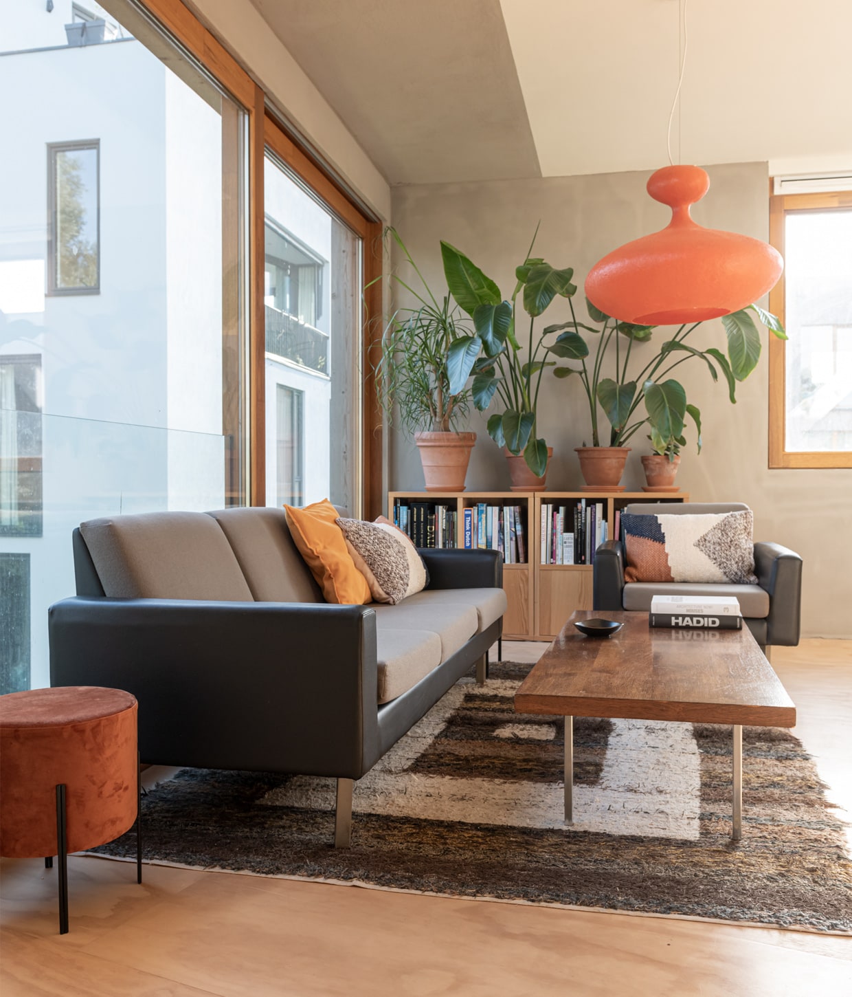 Bank en fauteuil Artifort bank uit jaren 60, hanglamp Kundalini E.T.A. Sat, poef Kwantum, oranje kussen gemaakt door Peters moeder, wollen kussens HKliving, salontafel Artifort KBD Liang Ie, boekenkasten Ikea, vloerkleed handgemaakt in Spanje, terracotta potten en schotels Intratuin en Ikea vtwonen 01-2021 | Productie en fotografie Caroline Martinot | Styling Sharon Roest
